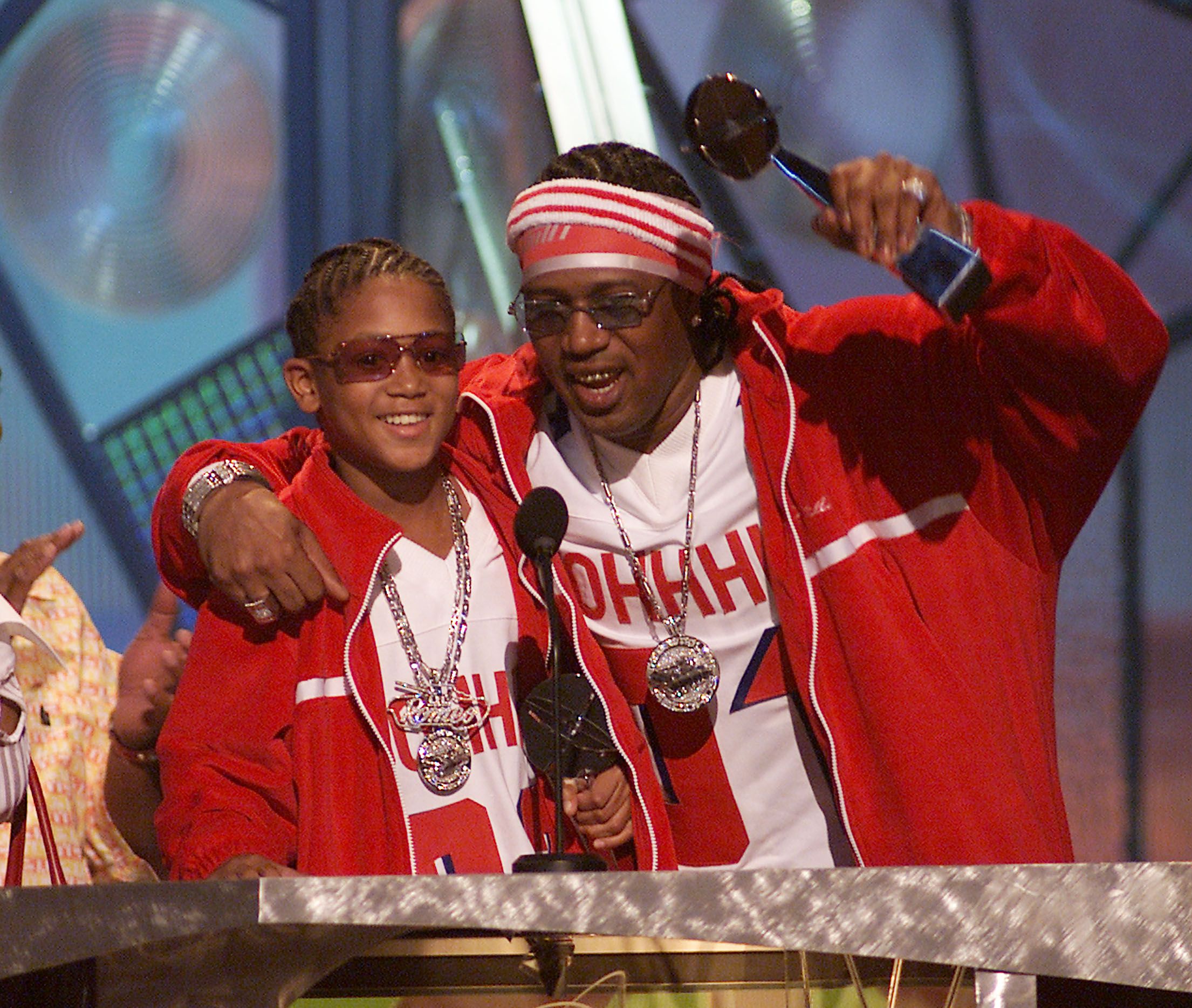 Master P holds up a trophy and hangs an arm around his son, Lil Romeo.