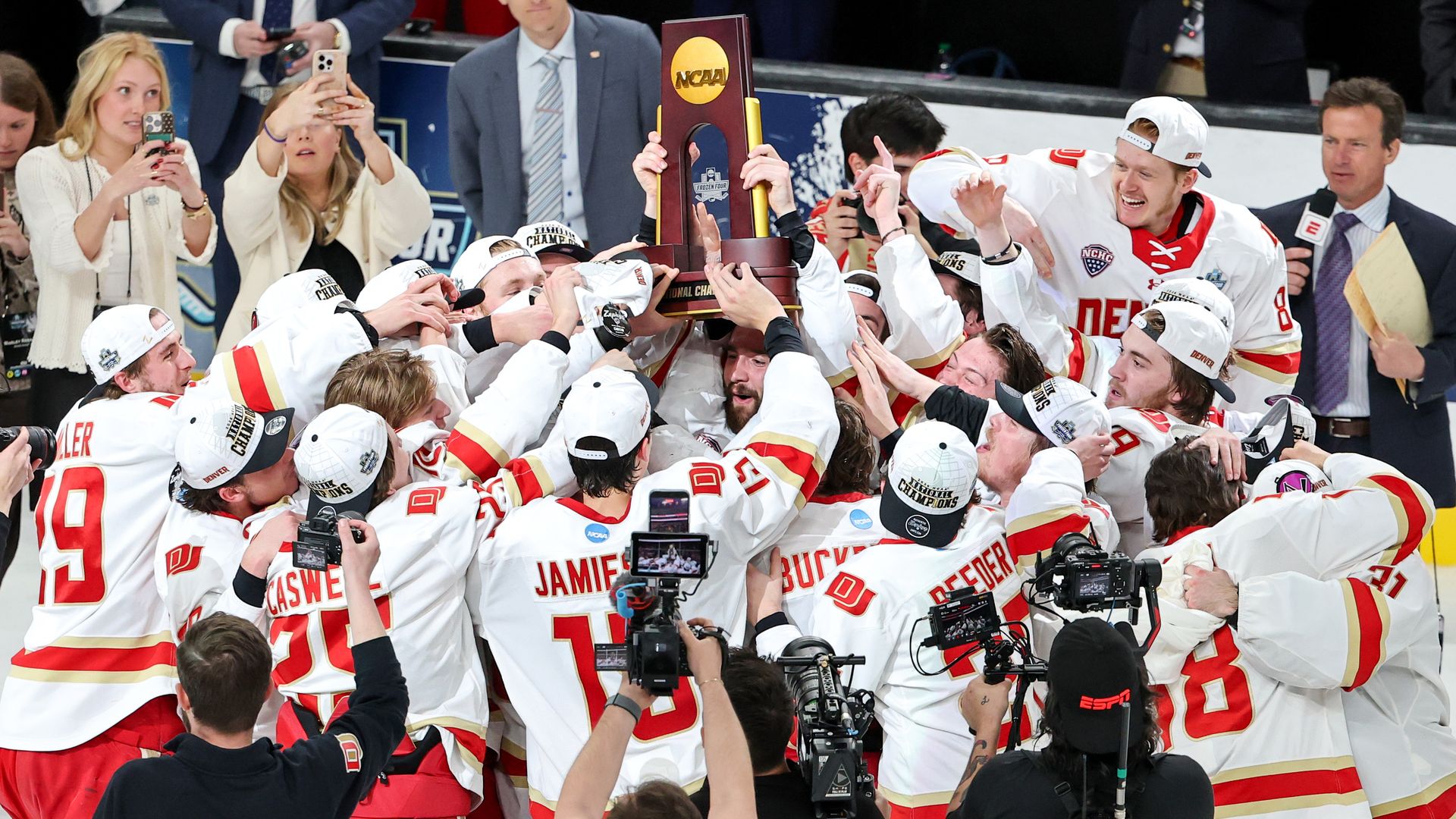 The Denver Pioneers celebrate with the trophy after the team's 2-1 victory over the Wisconsin Badgers to win the NCAA Division I men's ice hockey championship game Saturday. Photo: Ethan Miller/Getty Images