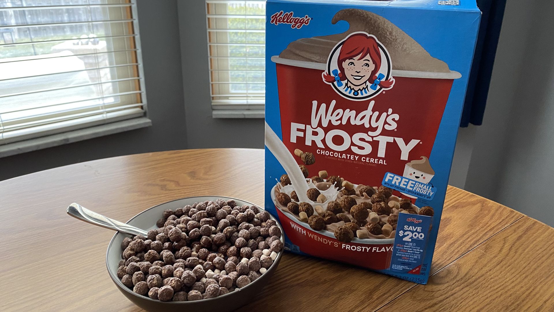 A box of Wendy's Frosty cereal next to a bowl of cereal with a spoon
