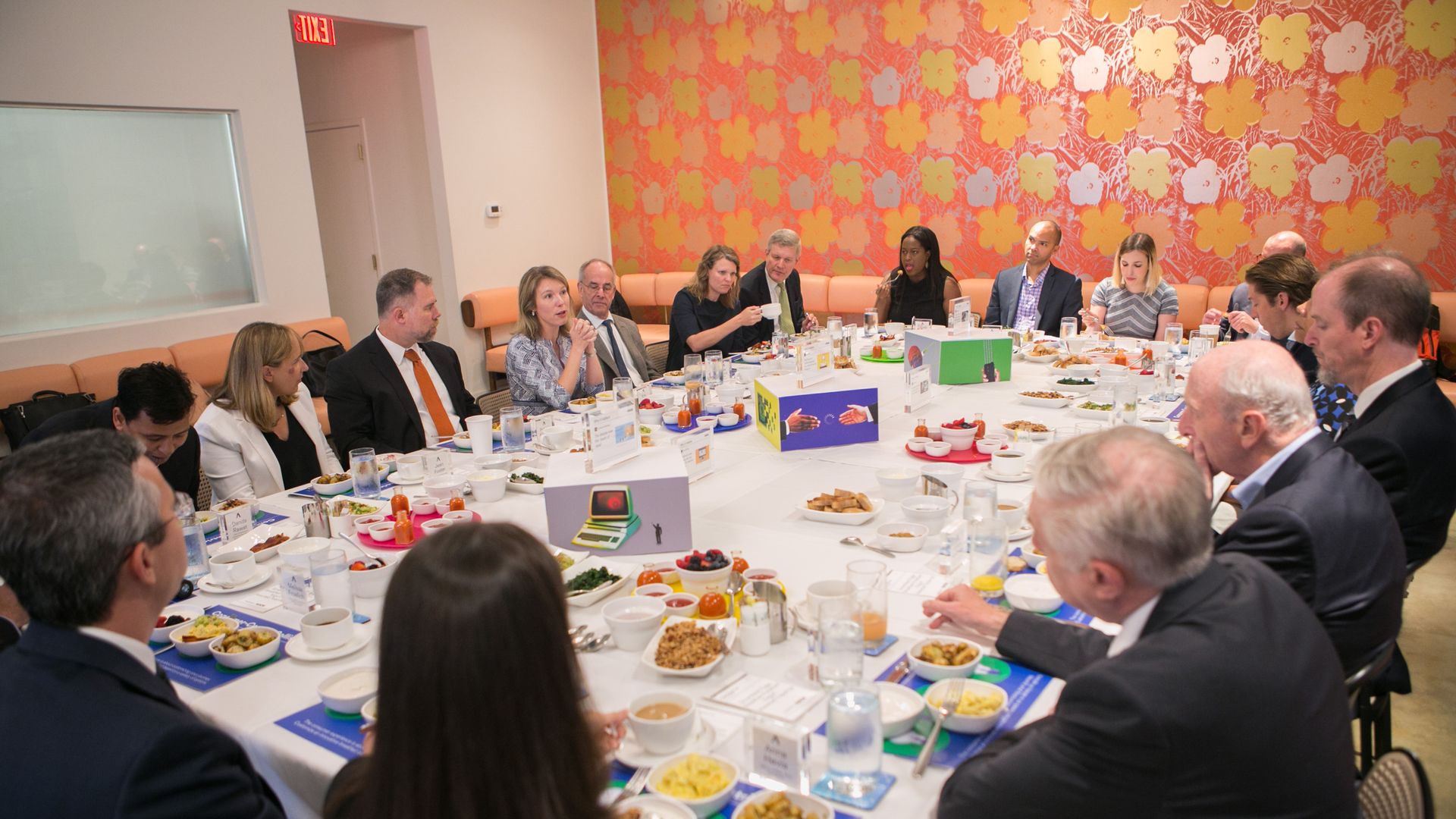 A large table with Kim Hart and 25 experts gathered for a conversation over breakfast