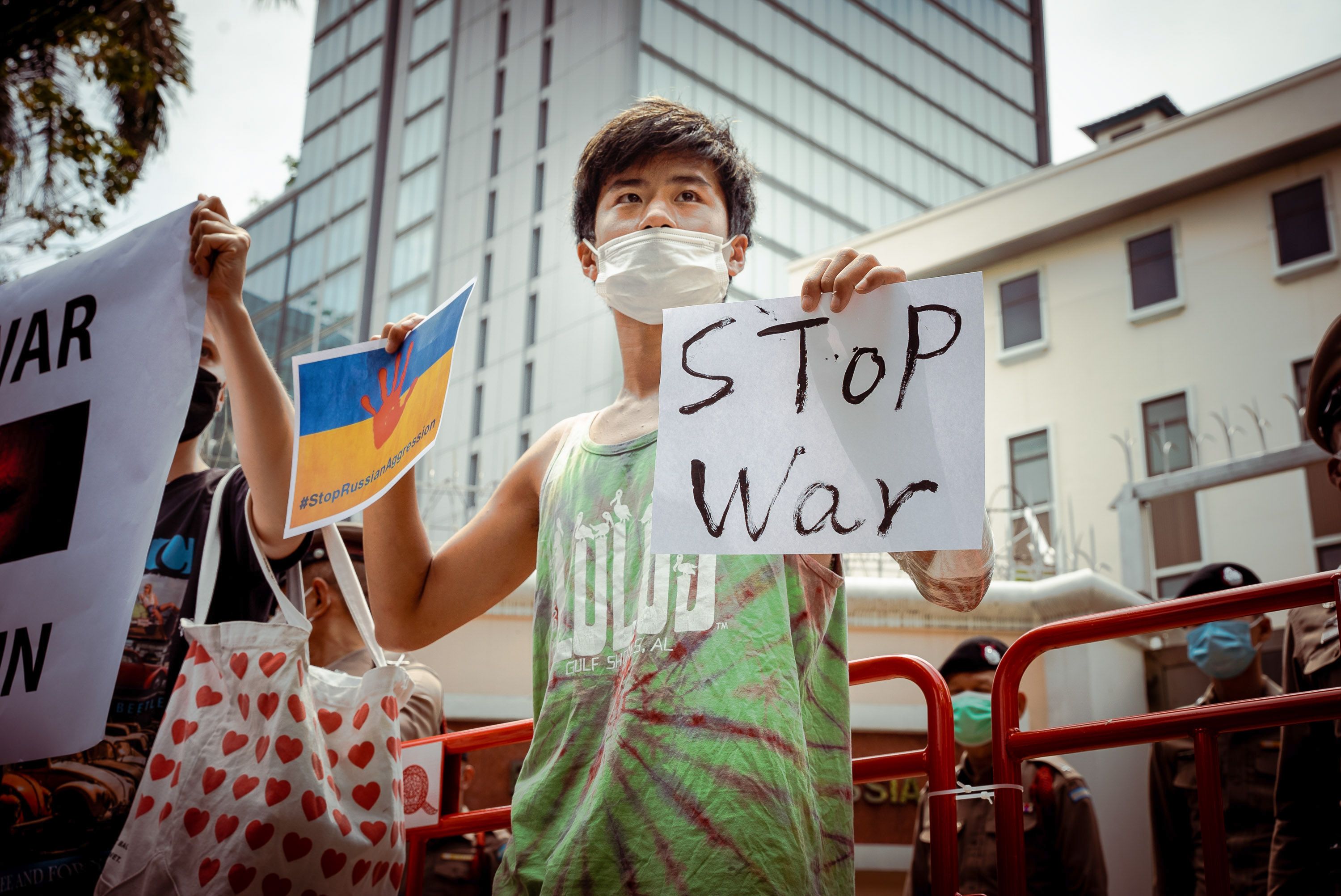 Photo of a person holding a sign that says "Stop war"