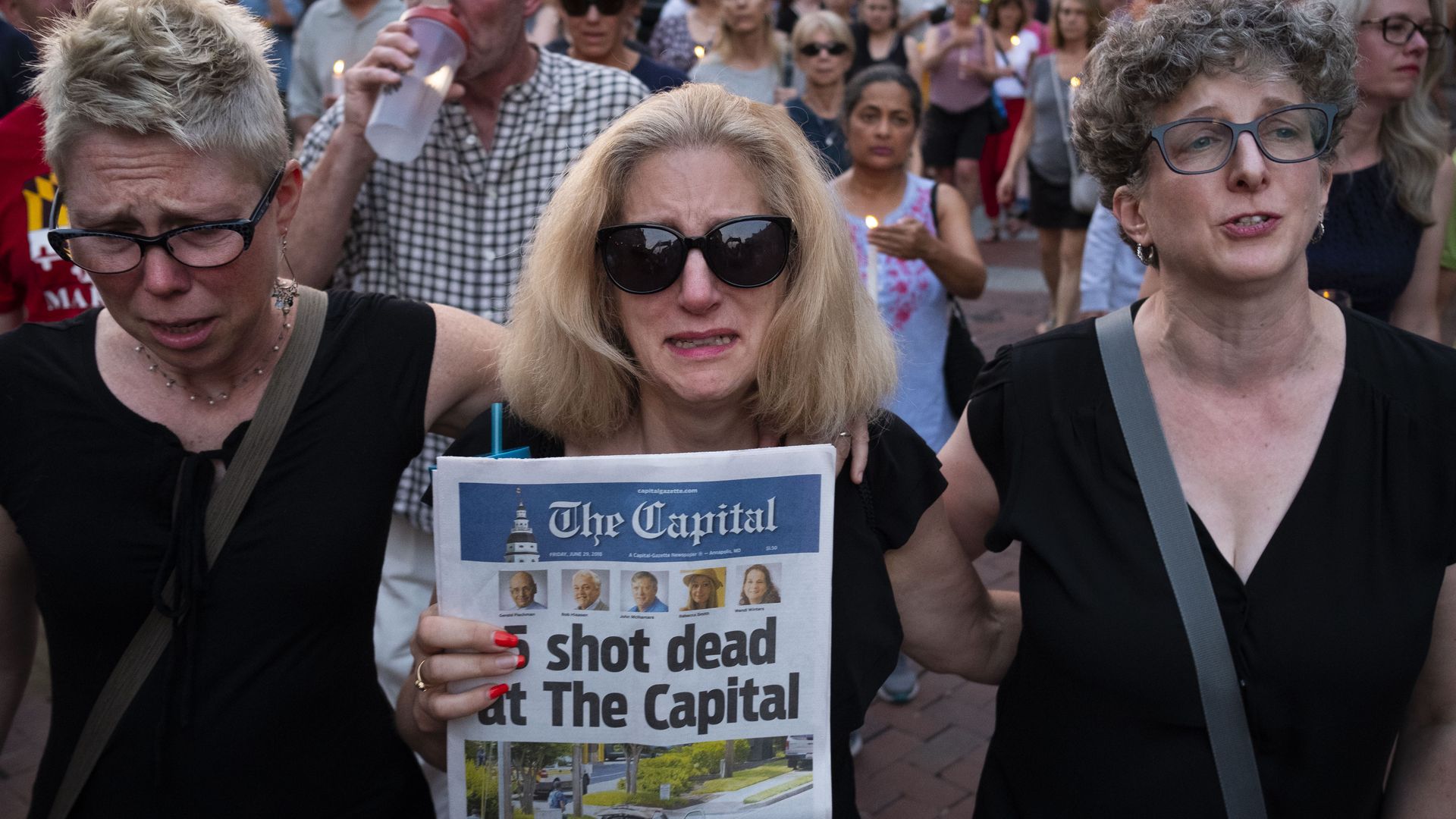 Three women marching at vigil. 