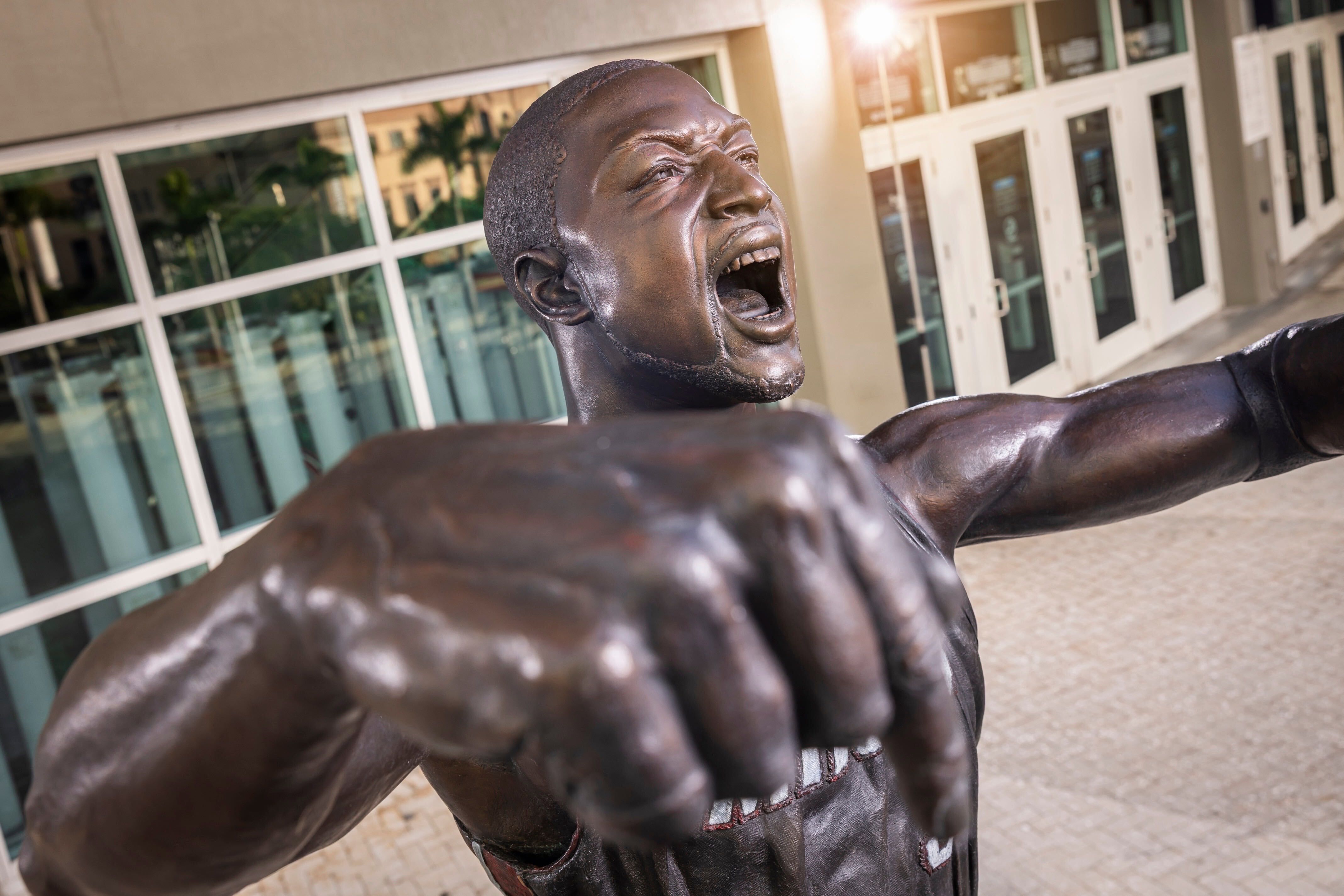 The new Dwyane Wade statue with a hyper-realistic face that more closely resembles the basketball player. The statue is yelling with fingers pointing down to say "This is my house"
