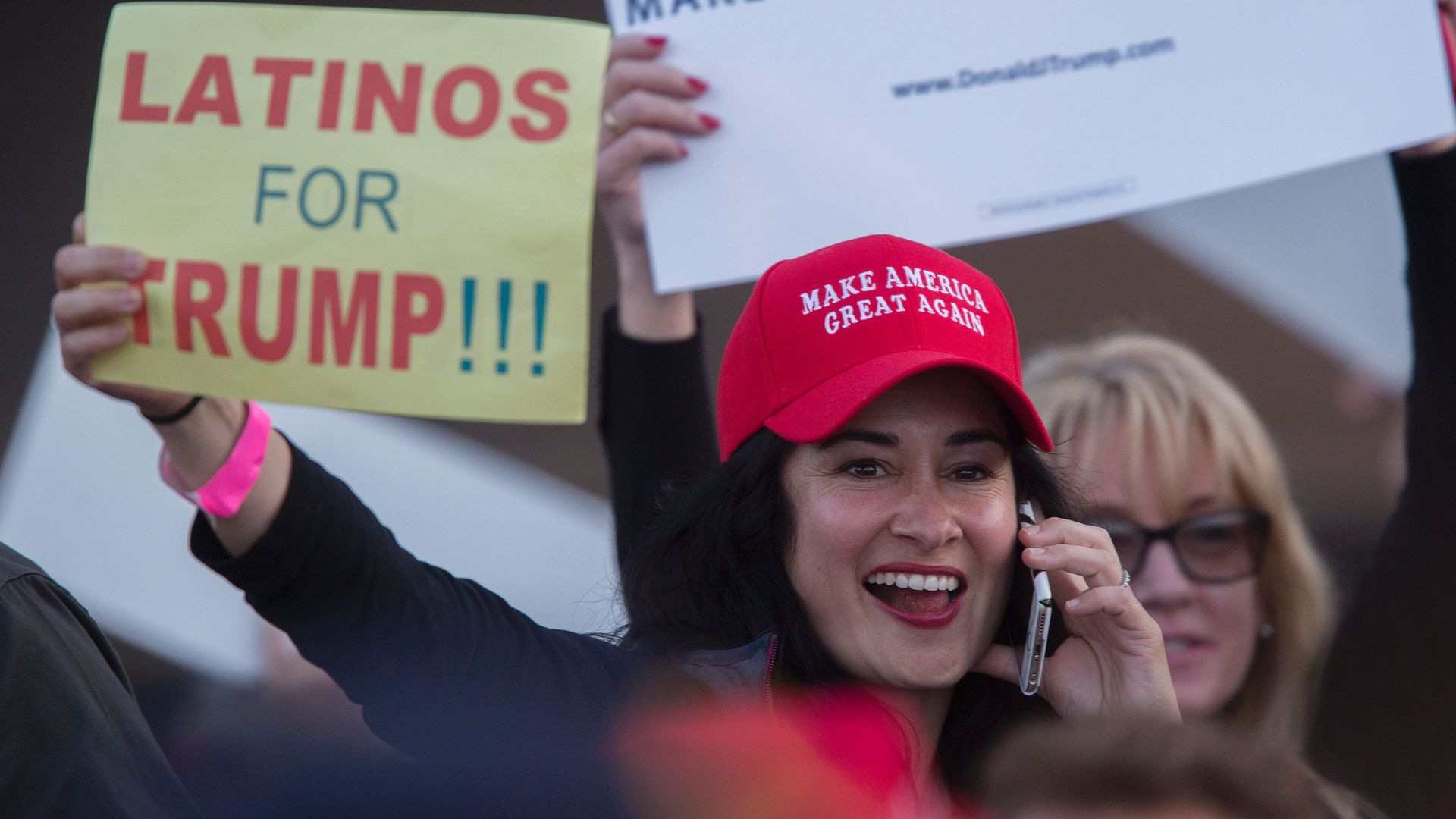 A woman holds a "Latinos for Trump" sign