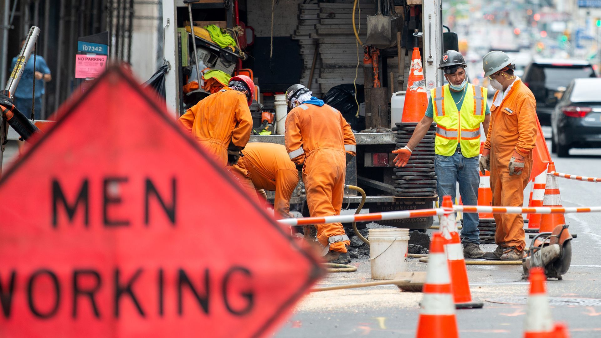 Construction workers wearing masks work on a road in New York City in May.