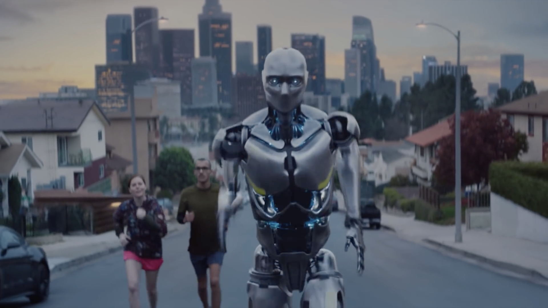 Image of a robot running past a pair of human joggers