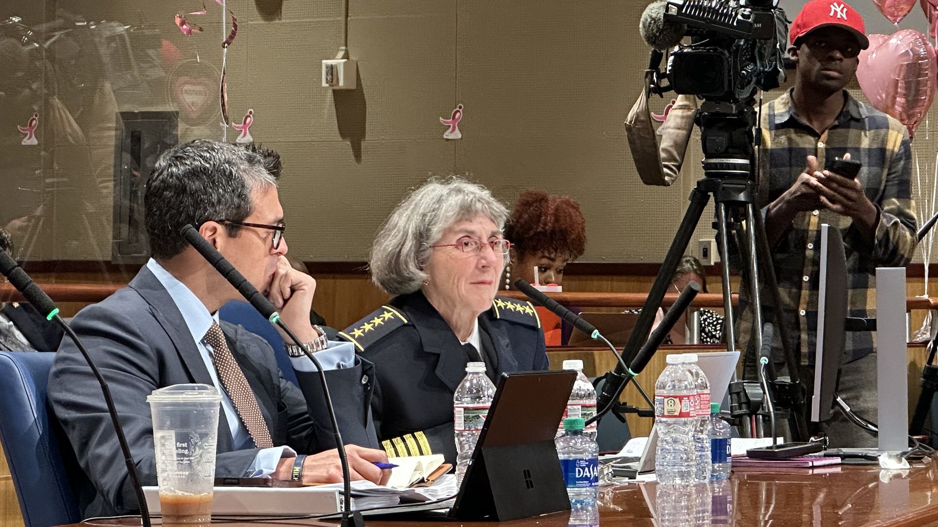 Photo shows interim NOPD police chief Anne Kirkpatrick sitting at a table with a TV camera next to her