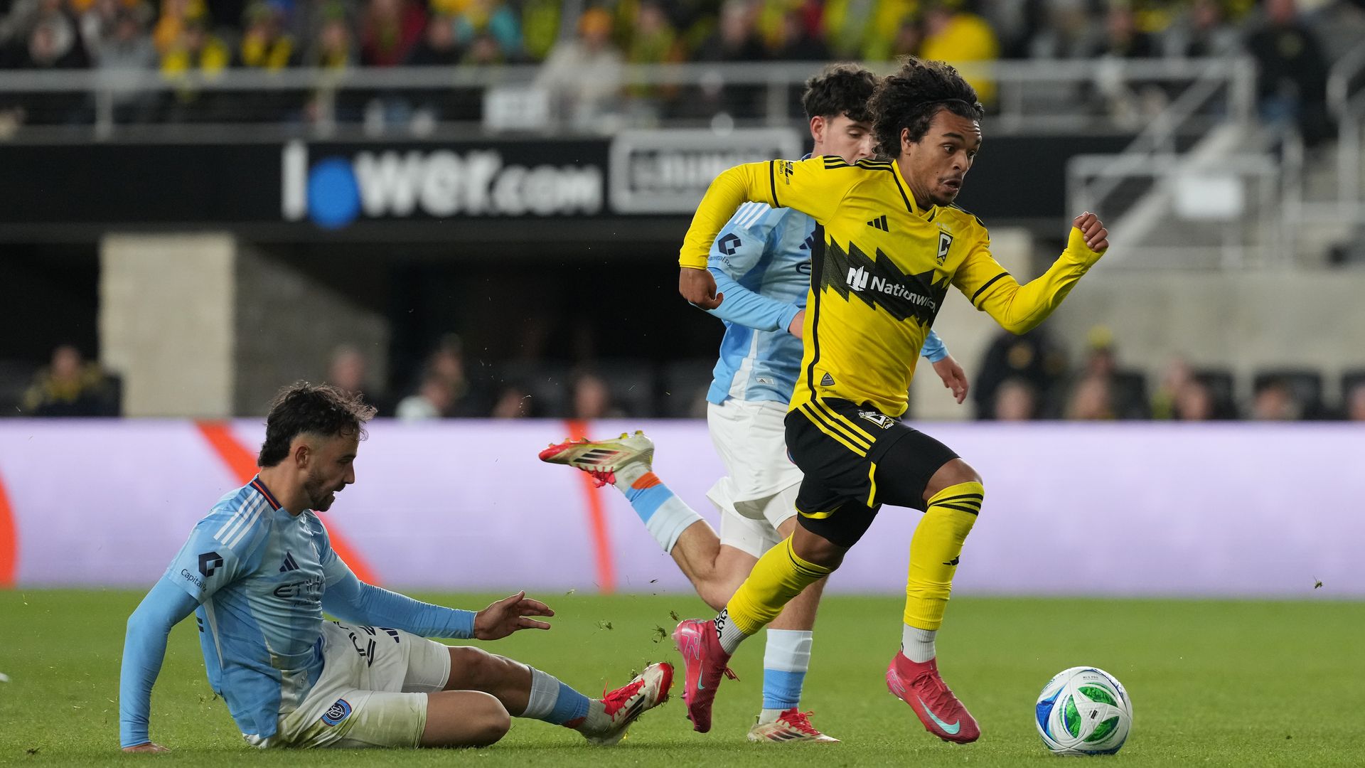 Columbus Crew's Aziel Jackson dribbles by two NYCFC players