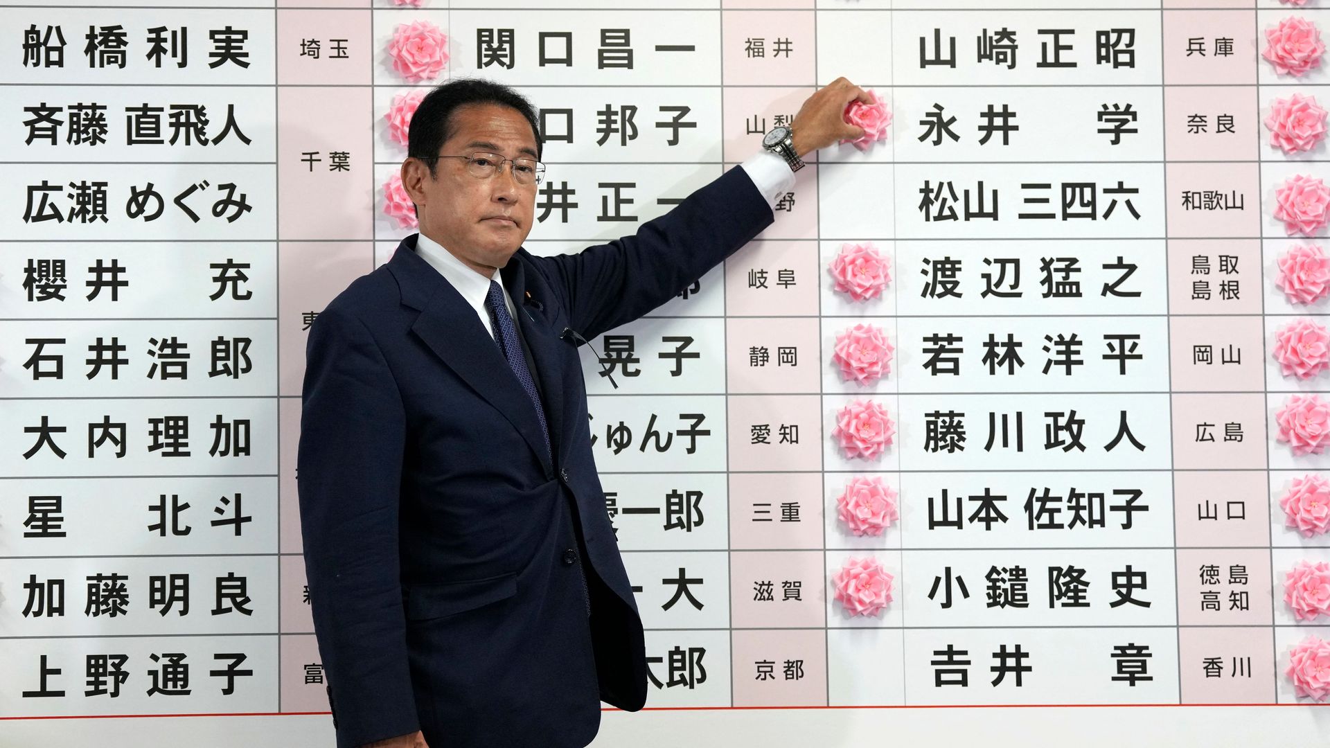 Japan's Prime Minister and the President of the Liberal Democratic Party (LDP) Fumio Kishida places a red paper rose on a LDP candidate's name to 