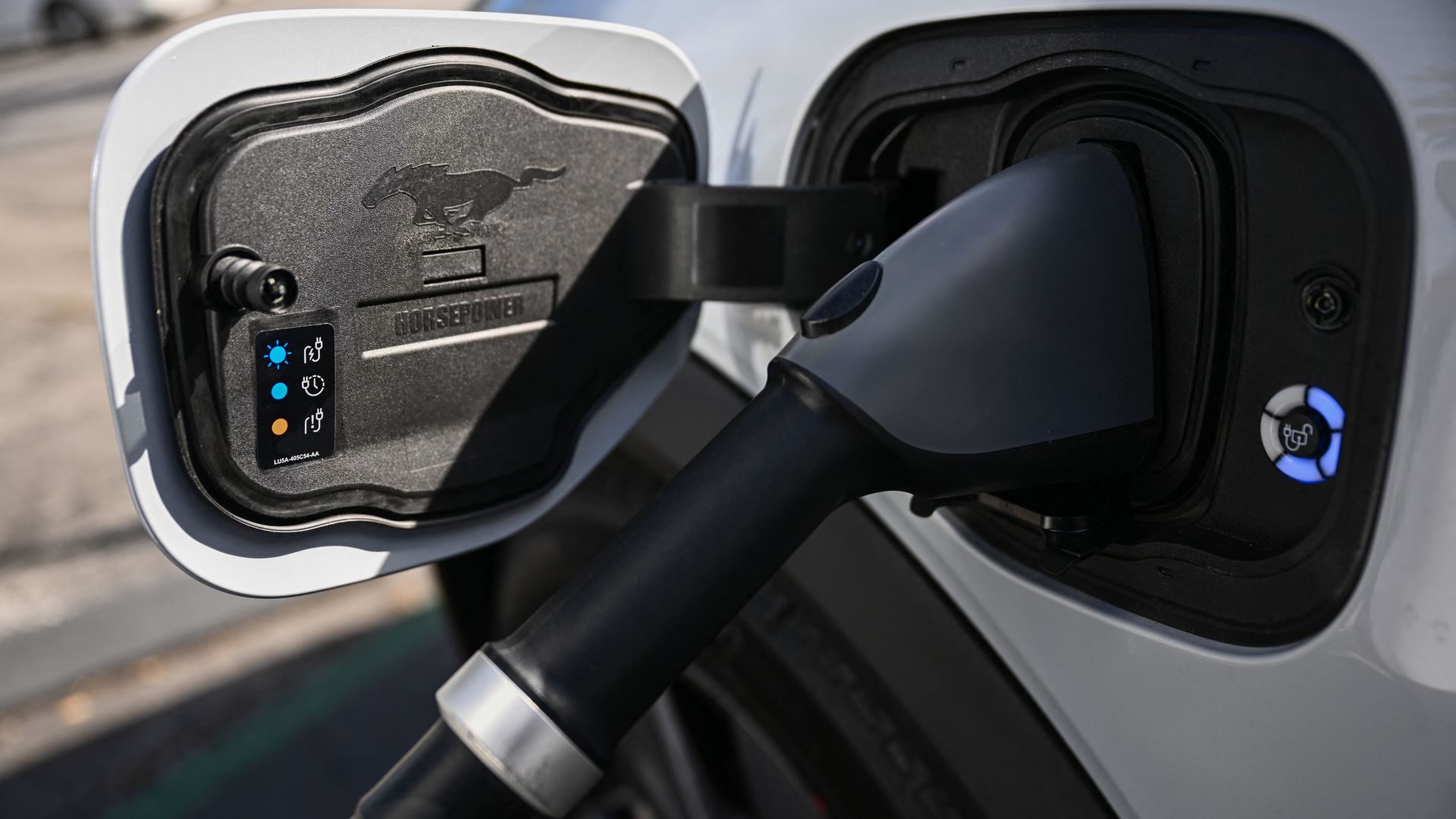 An EV plug is plugged into a Ford Mustang Mach-E