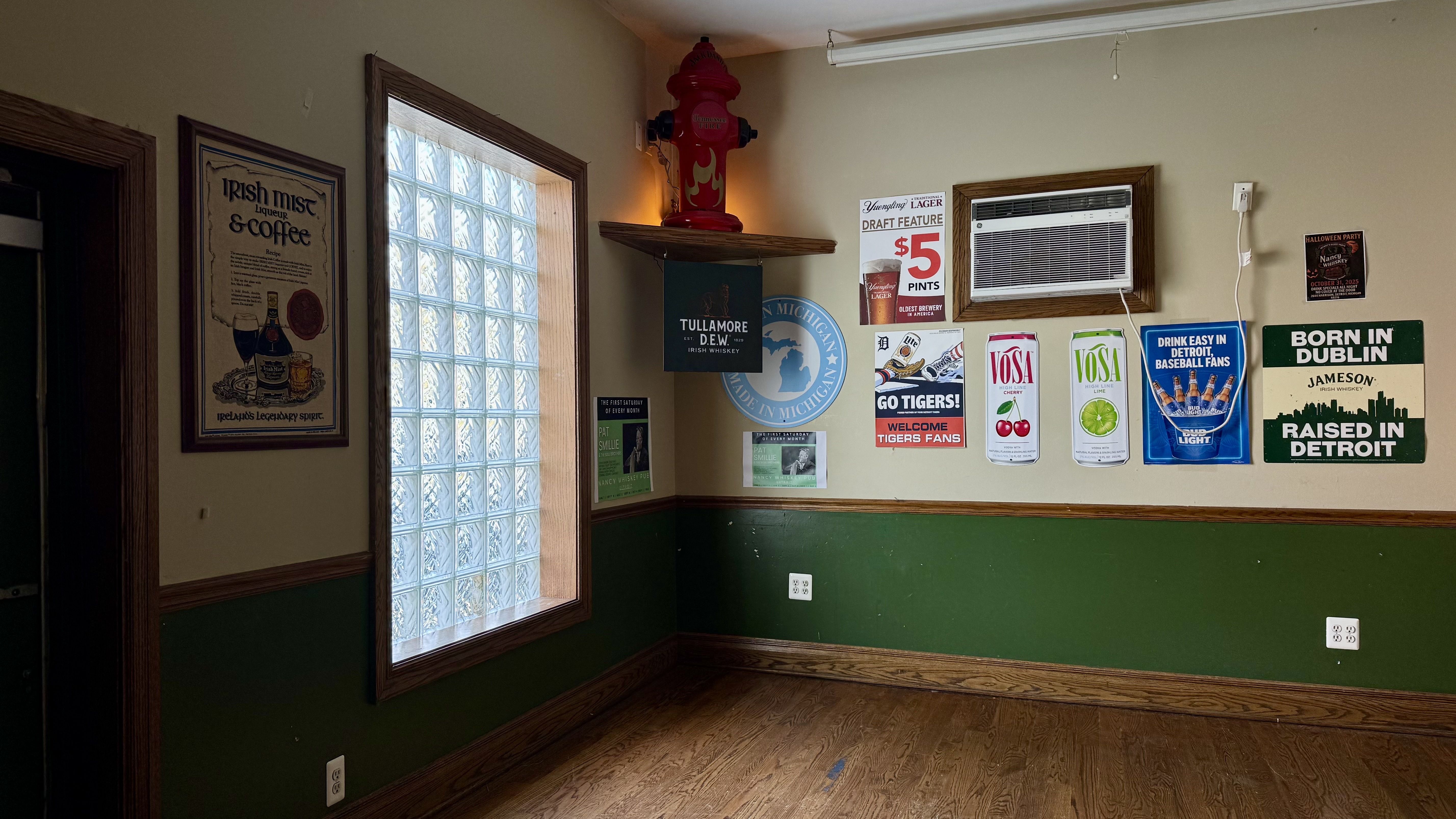 A window is shown in the establishment with a large ledge. it's surrounded by old ads that create a cool atmosphere