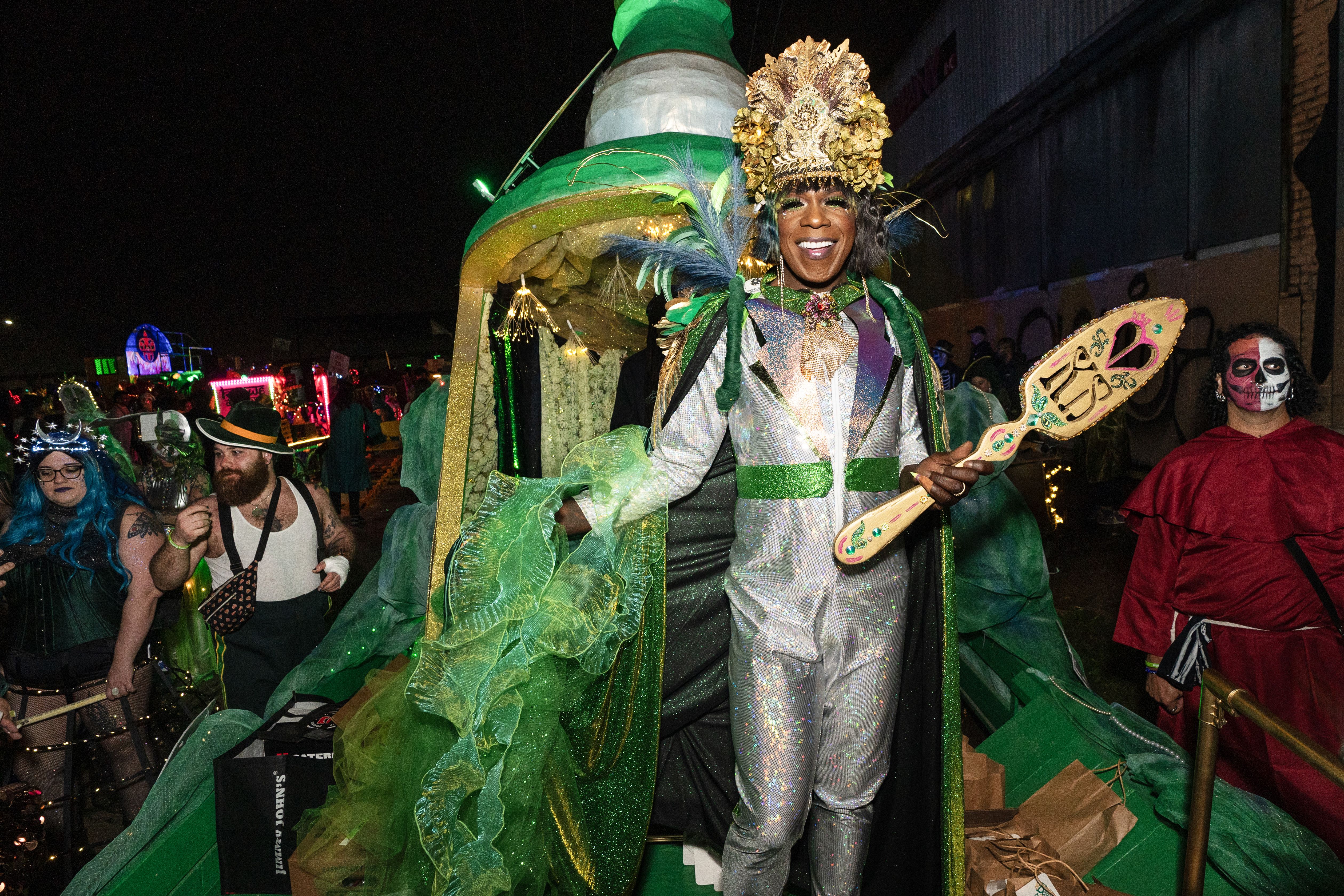 Photo shows Big Freedia in a silver outfit on a green float
