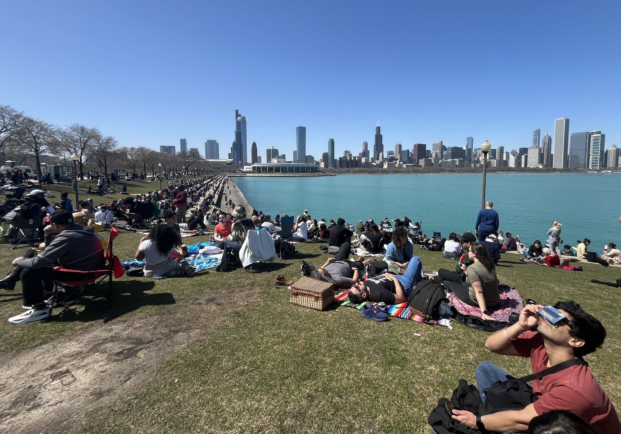 People on the lakefront with skyline in background.