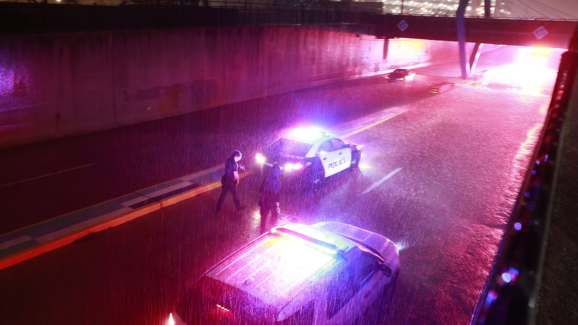 A pedestrian seeks help from police due to their flooded car during a thunderstorm.