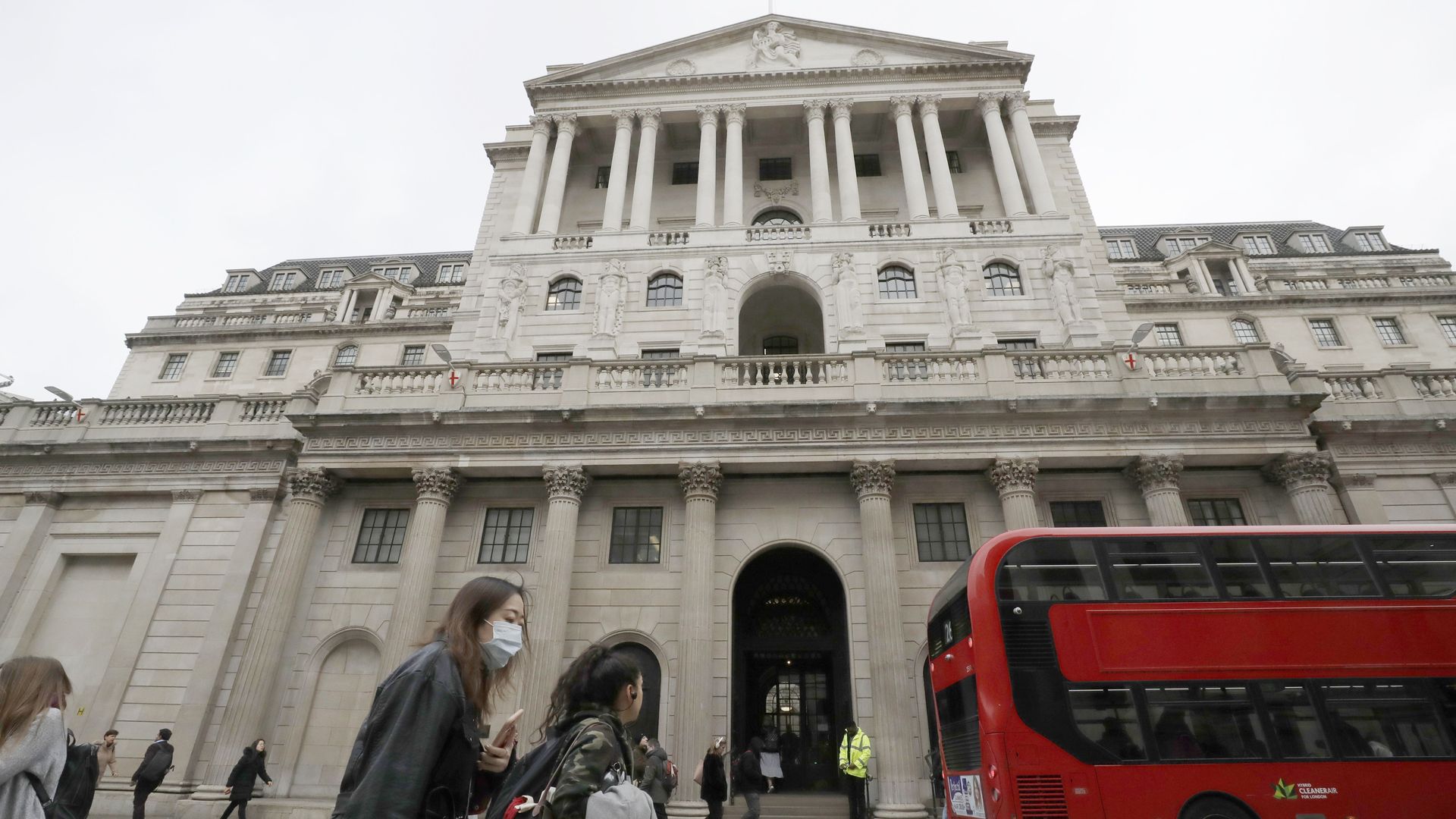 In this image, two women walk past the Bank of England in London