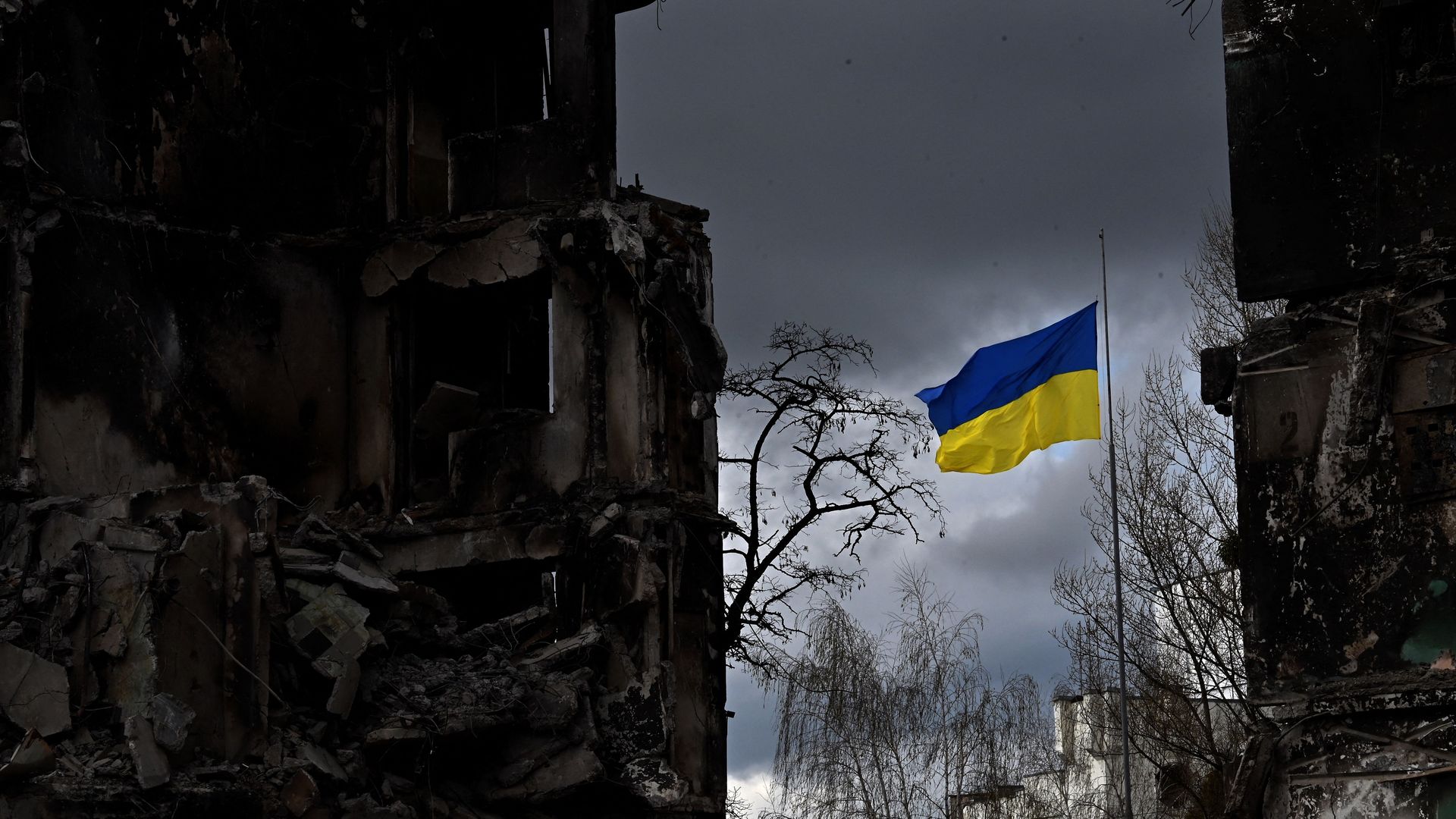 A Ukrainian flag amid rubble.