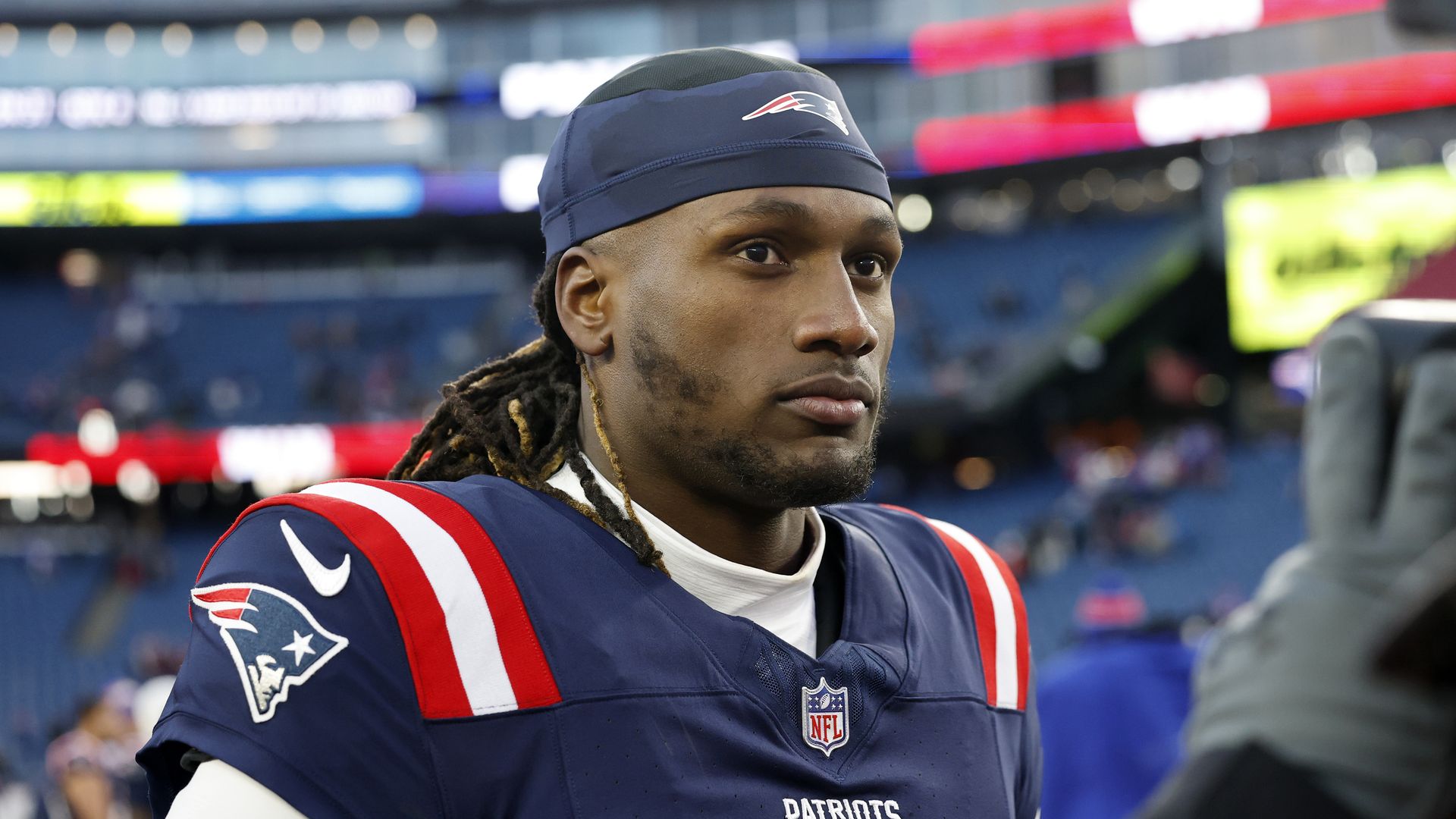 A football player wearing a blue and red jersey looks ahead