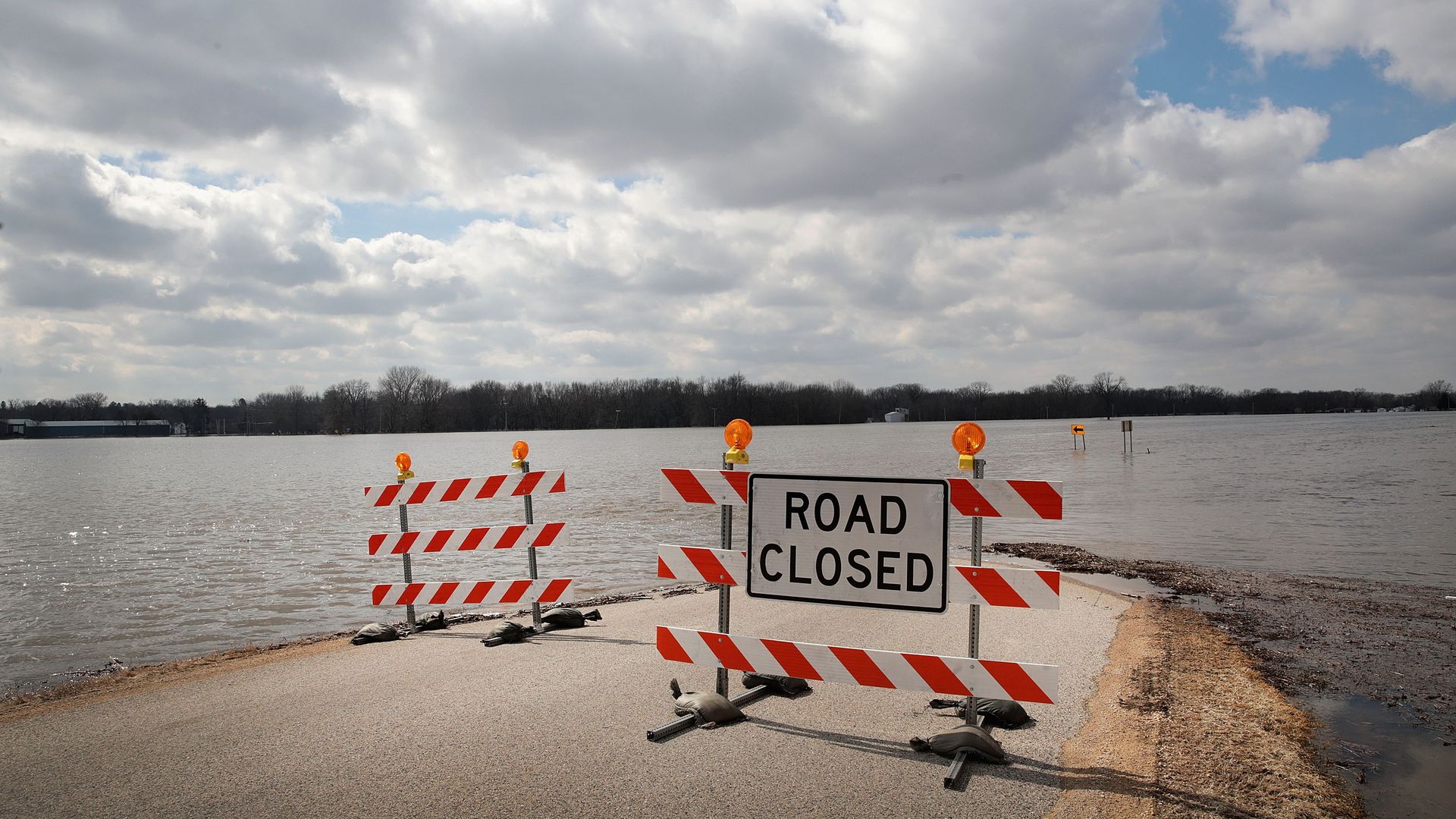 A road is covered with floodwater from the Pecatonica River