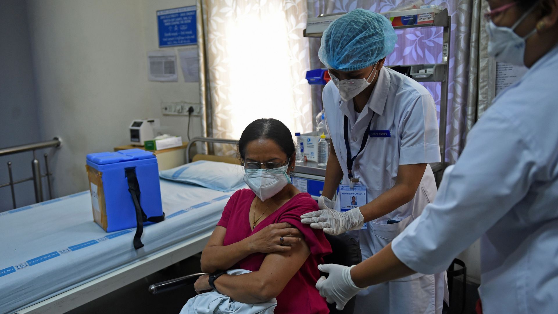 Picture of a medical worker in India vaccinating a doctor