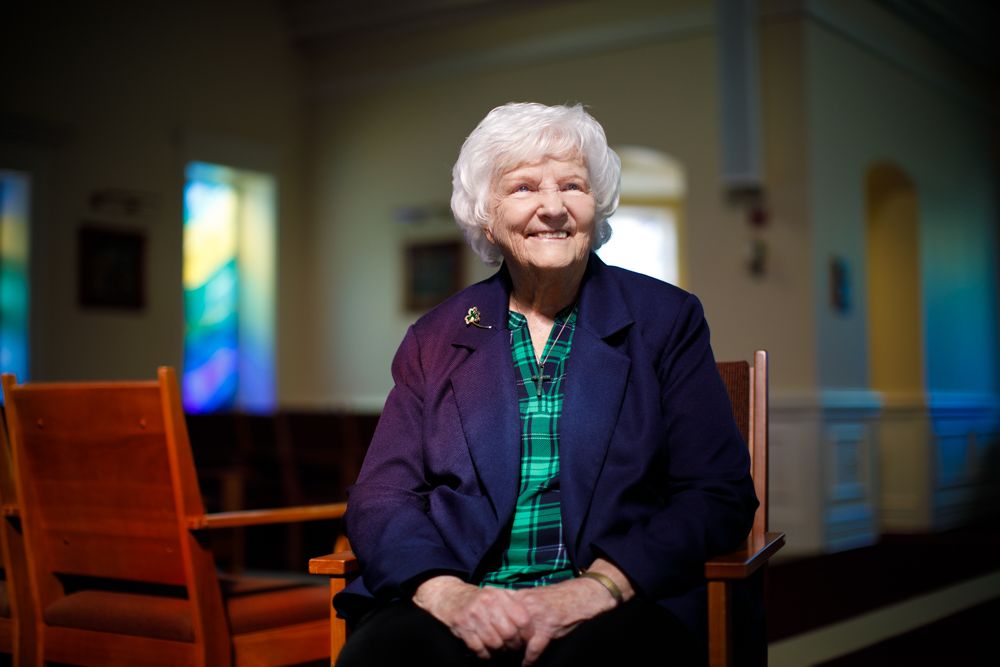 Sister Rosemary Connelly in a blue blazer and green and black plaid shirt smiling.