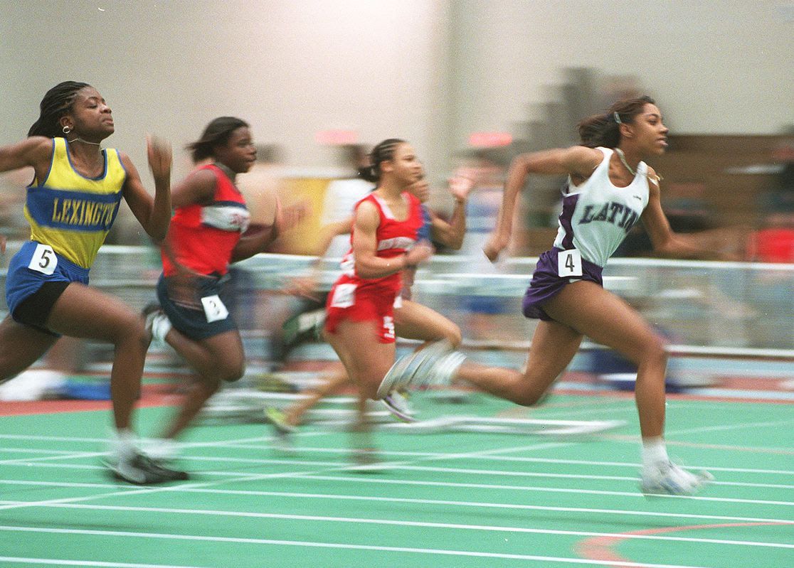 People running at a high school track meet. 