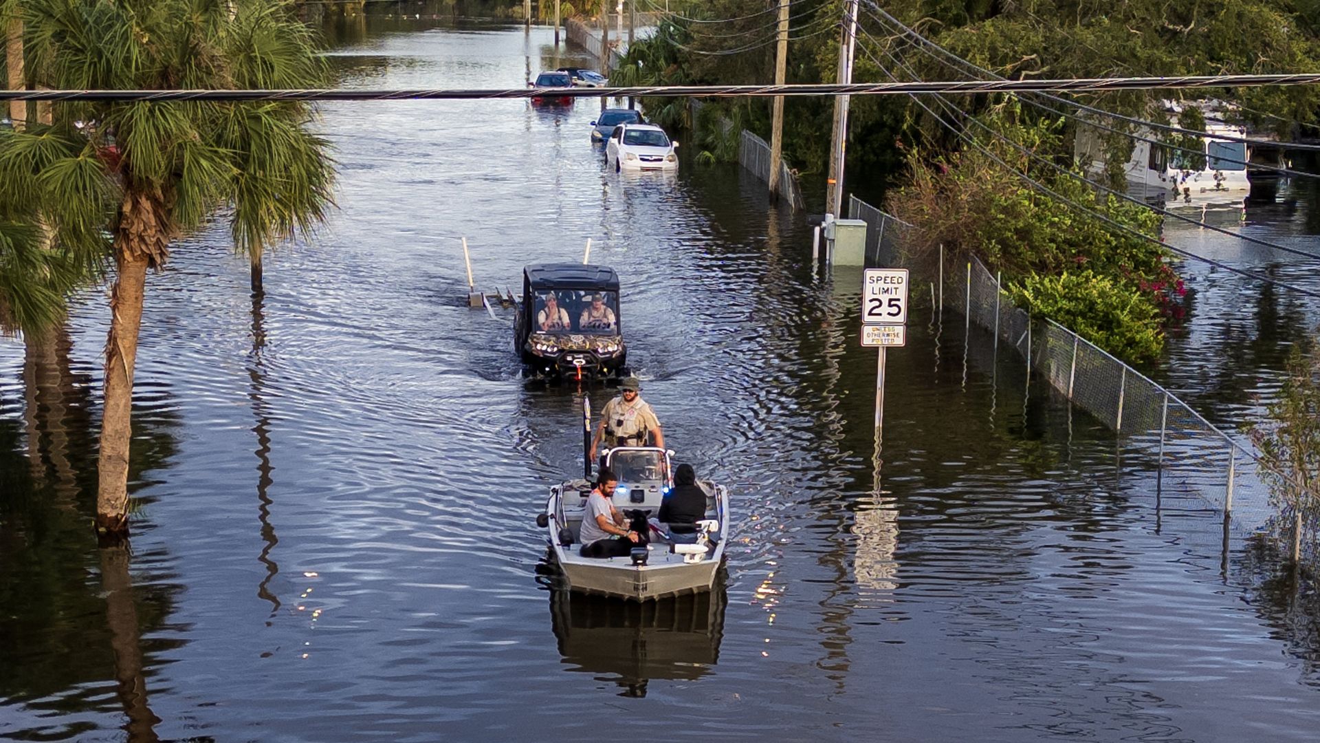 Florida Fish and Wildlife Conservation Commission officers ride on a flats boat through the flooded N 12th St in North Tampa.