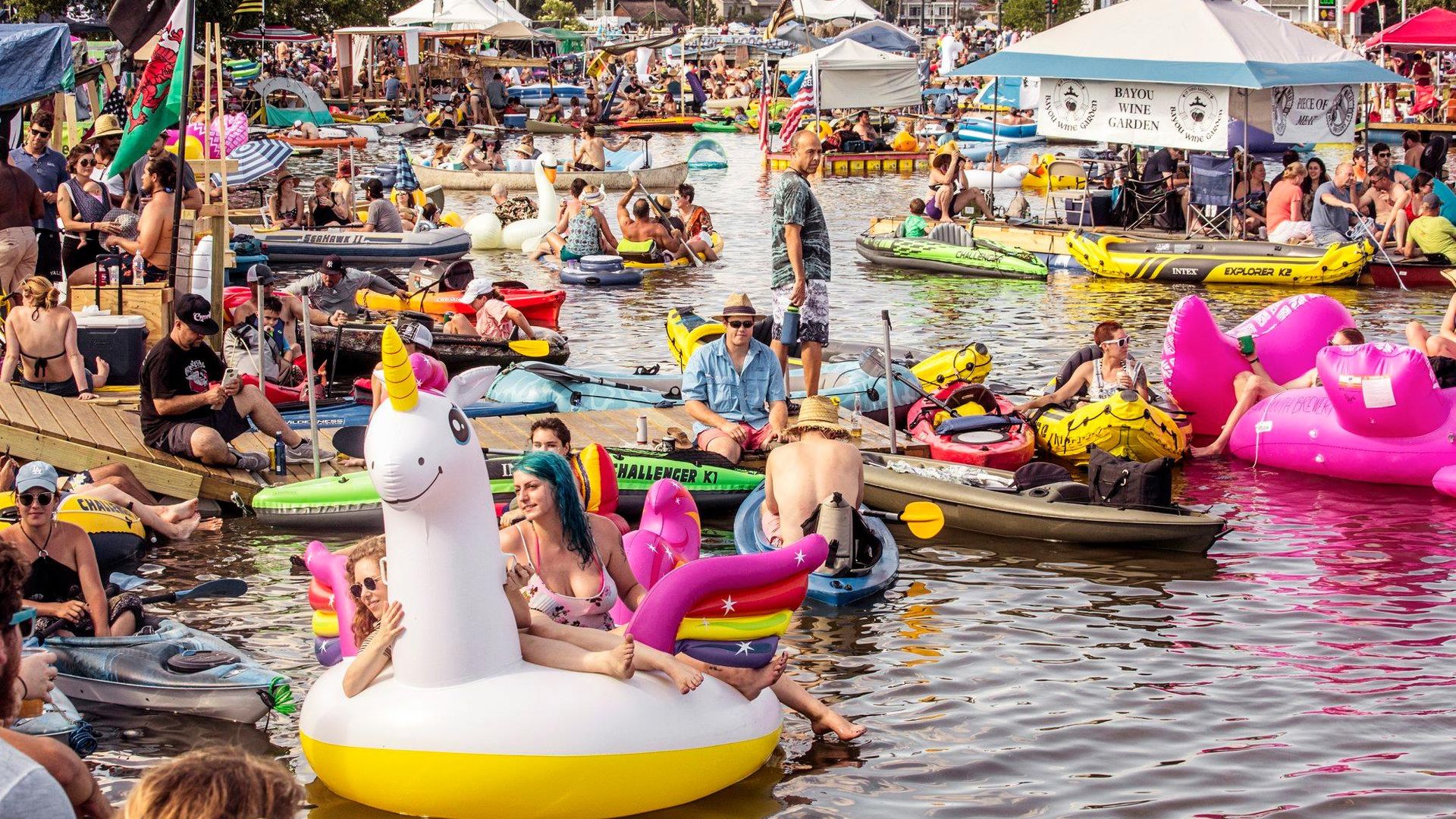 A photo of Bayou St. John shows the waterway filled with canoes, kayaks and floaties as revelers enjoy the festival.