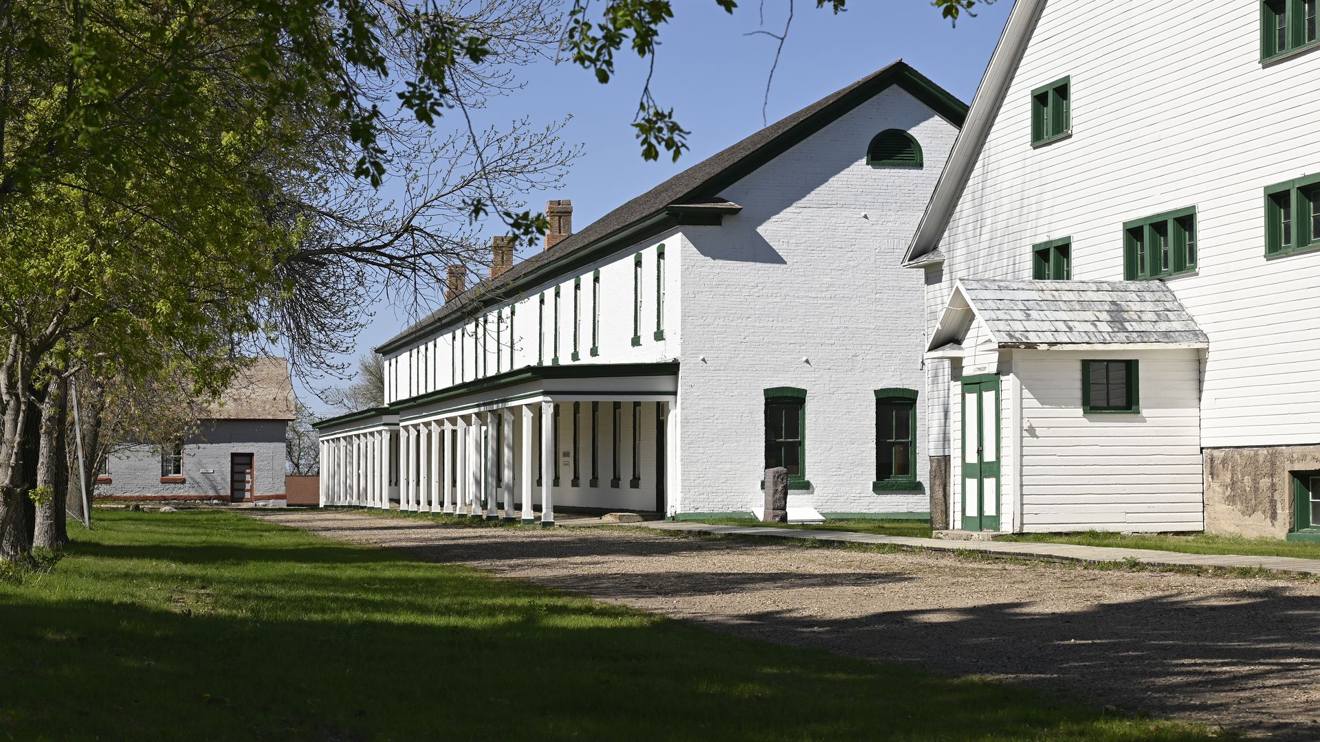 A pair of whitewashed old-style buildings in a rural setting