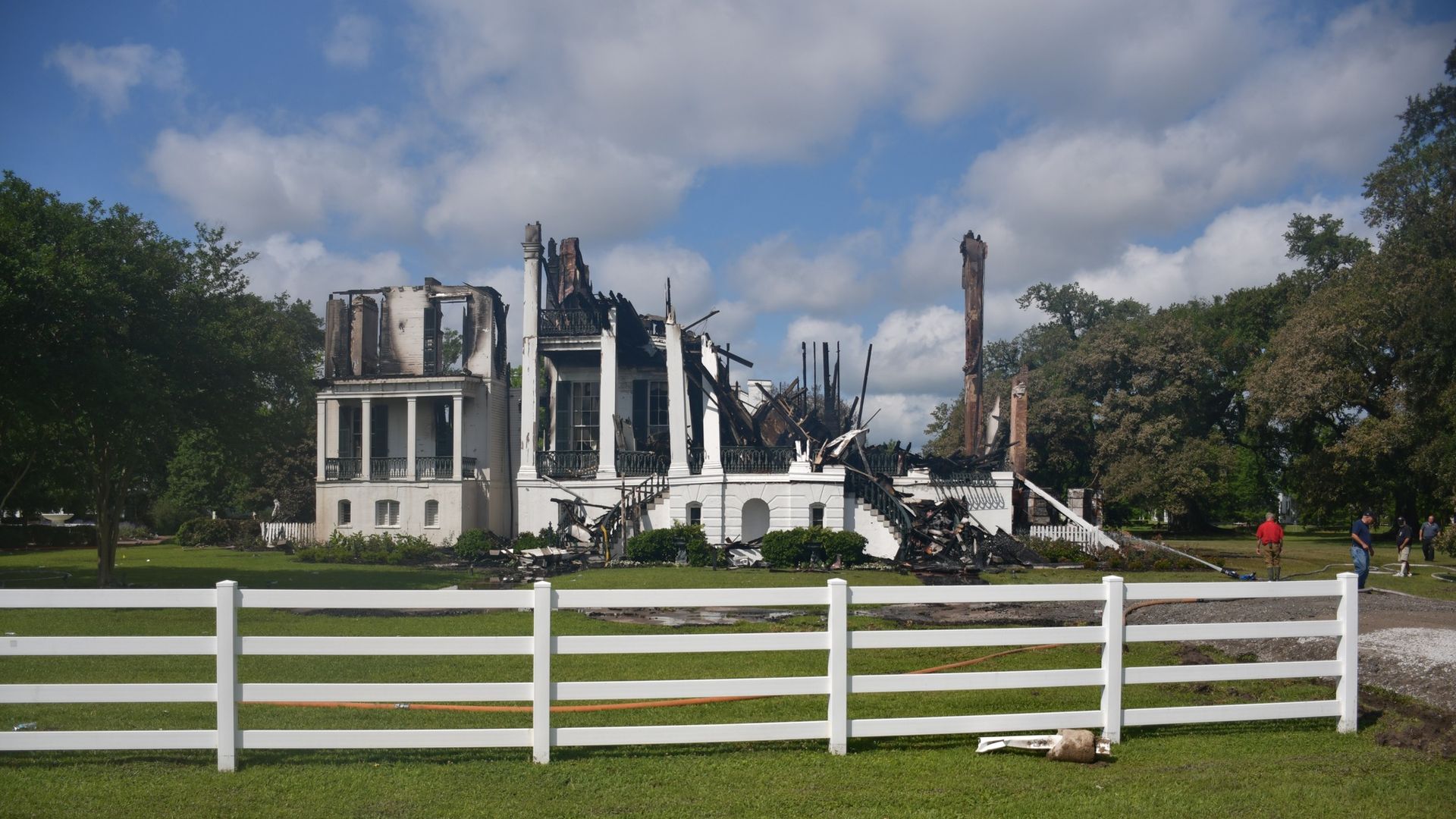 A white mansion is shown burned to the ground.