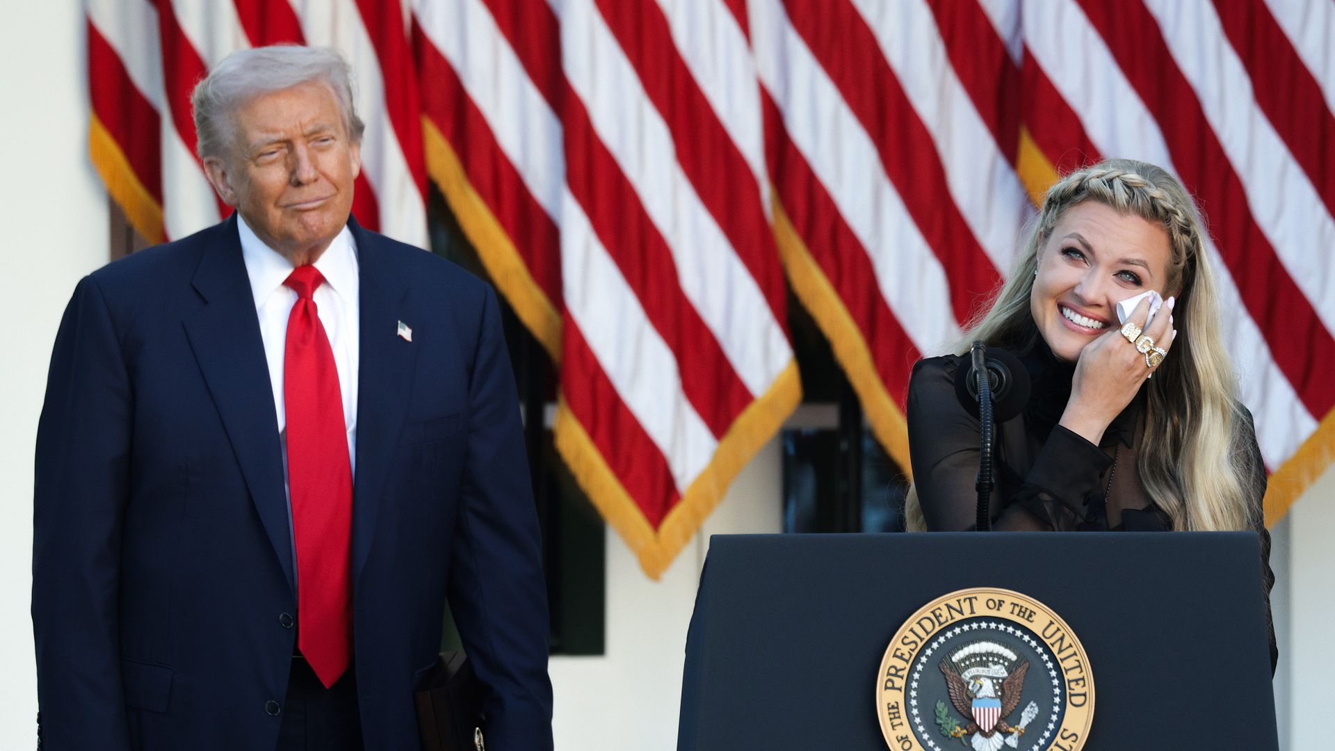 Erika Kirk (R), wife of late conservative activist Charlie Kirk, wearing all black, wipes away a tear beside President  Trump (L) posthumously awarded the Presidential Medal of Freedom to Charlie Kirk during a ceremony in the Rose Garden of the White House on October 14.