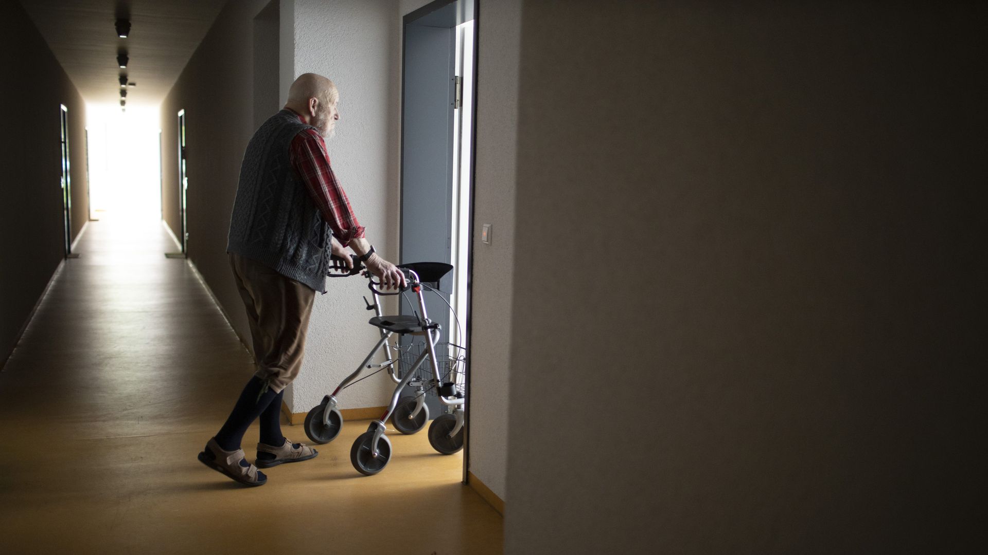 A person uses a walker to navigate a doorway.