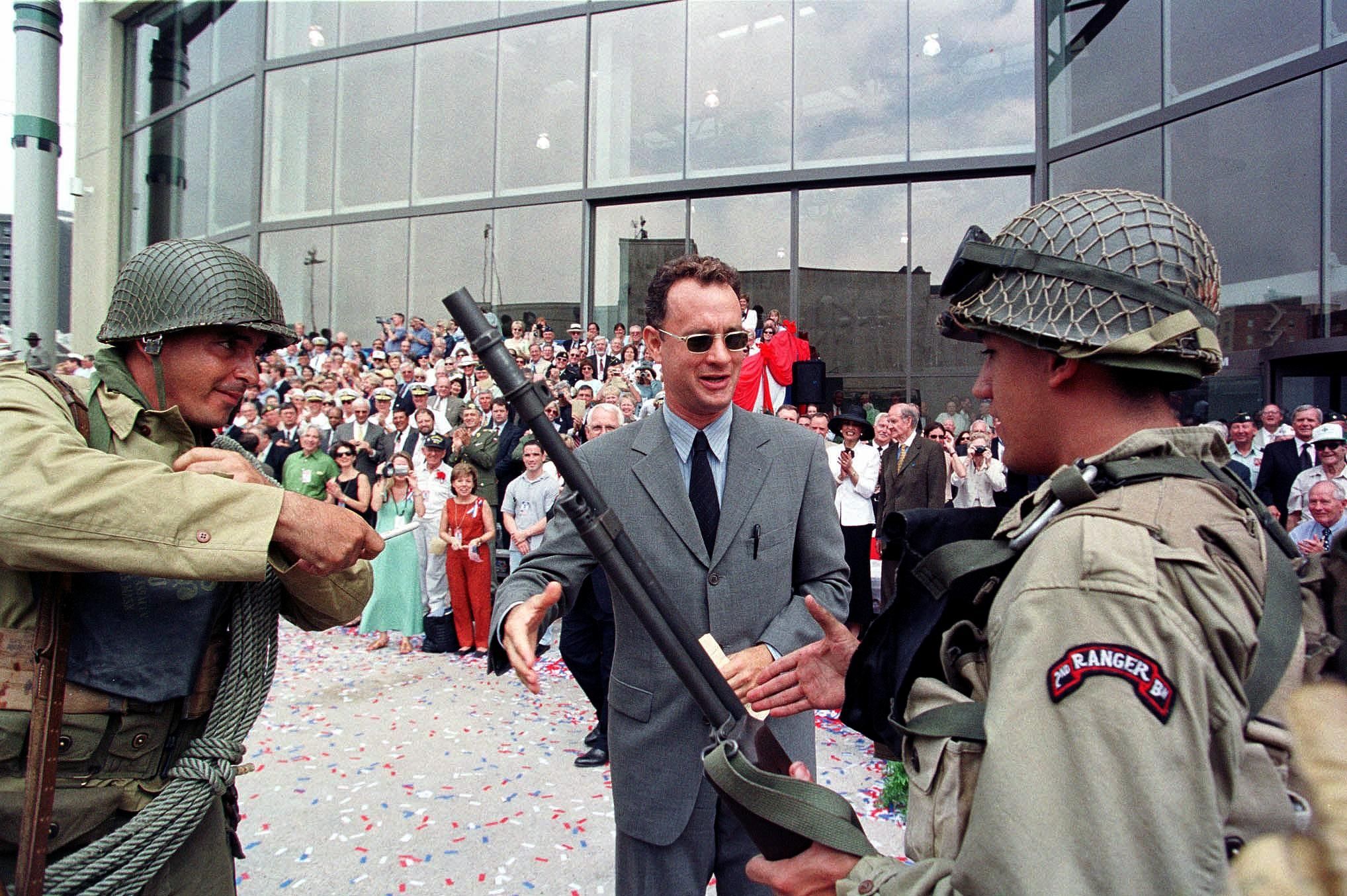 Image shows Tom Hanks with soldier re-enactors.