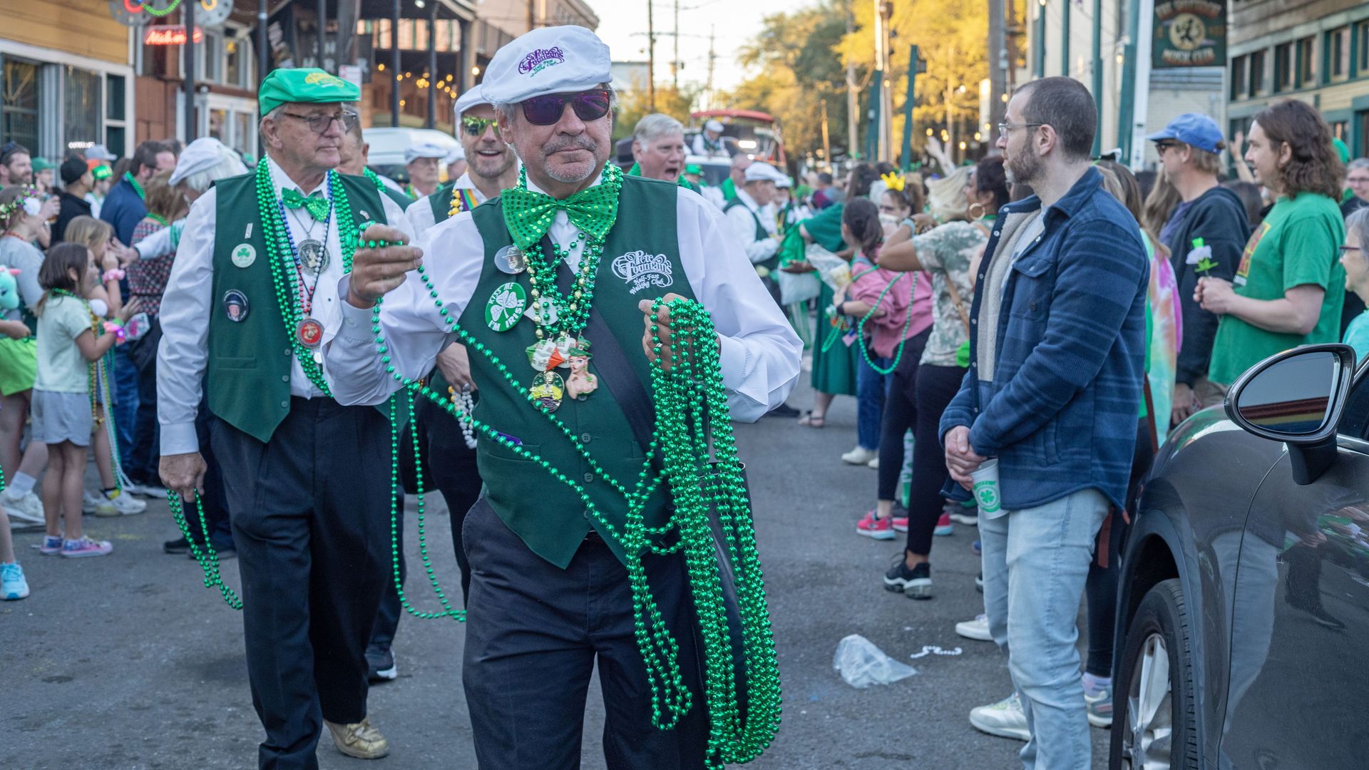 Image shows men dressed in green with green beads.