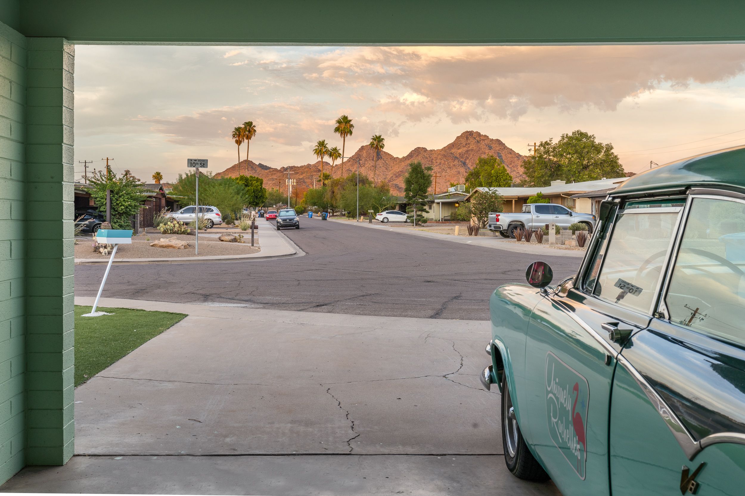 A turquoise convertible with a mountain range in the background. 