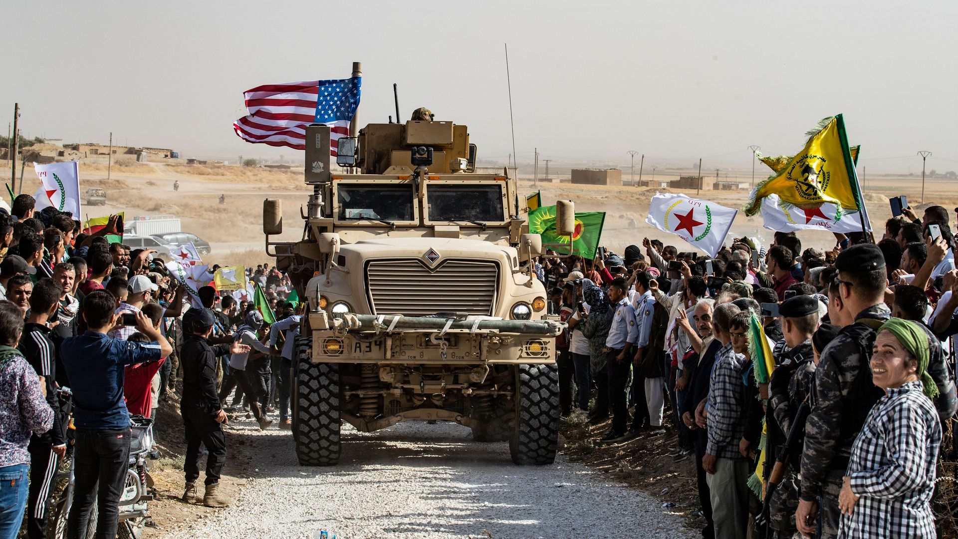 Syrians gather around a U.S. armored car