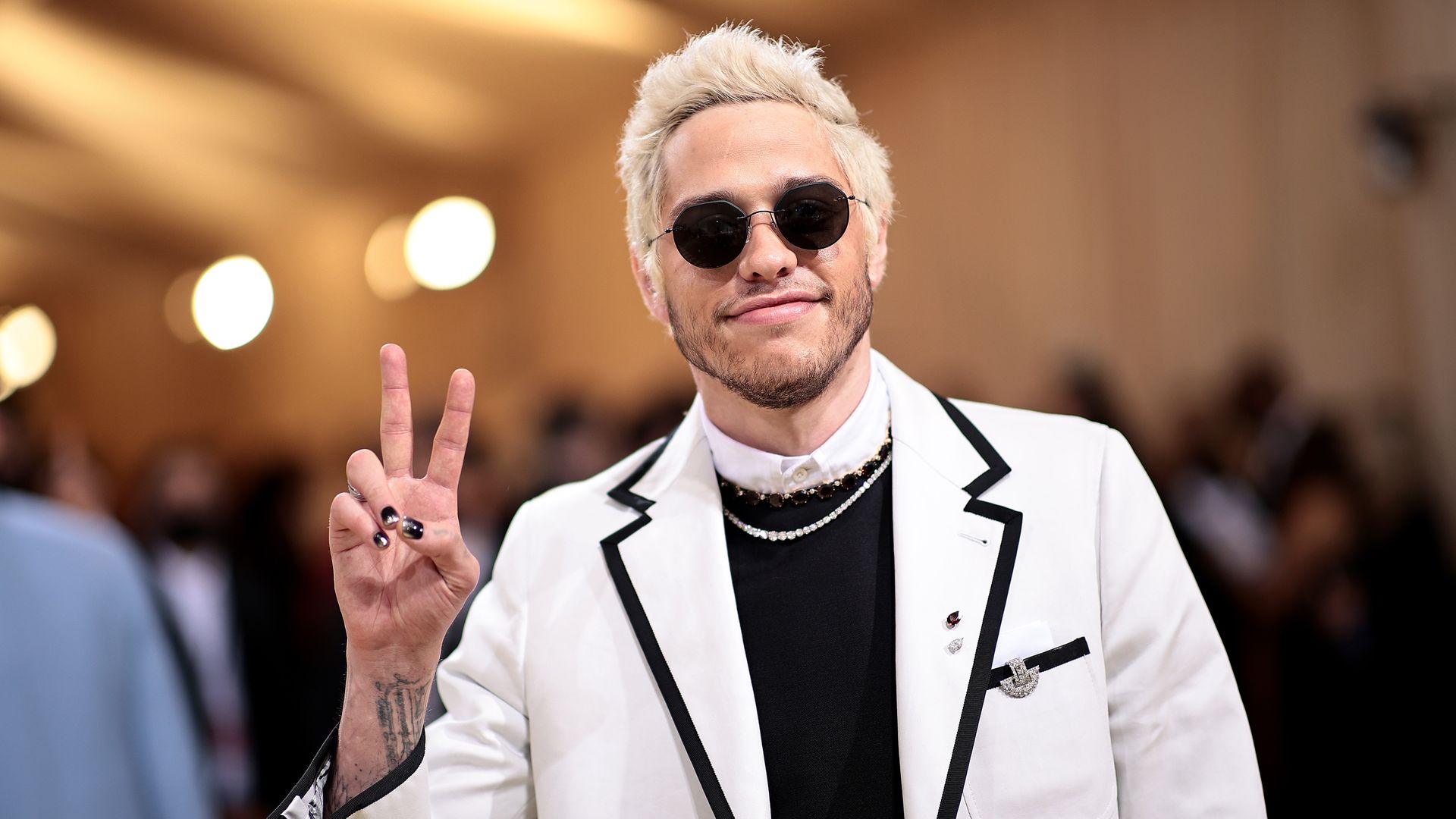 Pete Davidson holding up the peace sign with his fingers