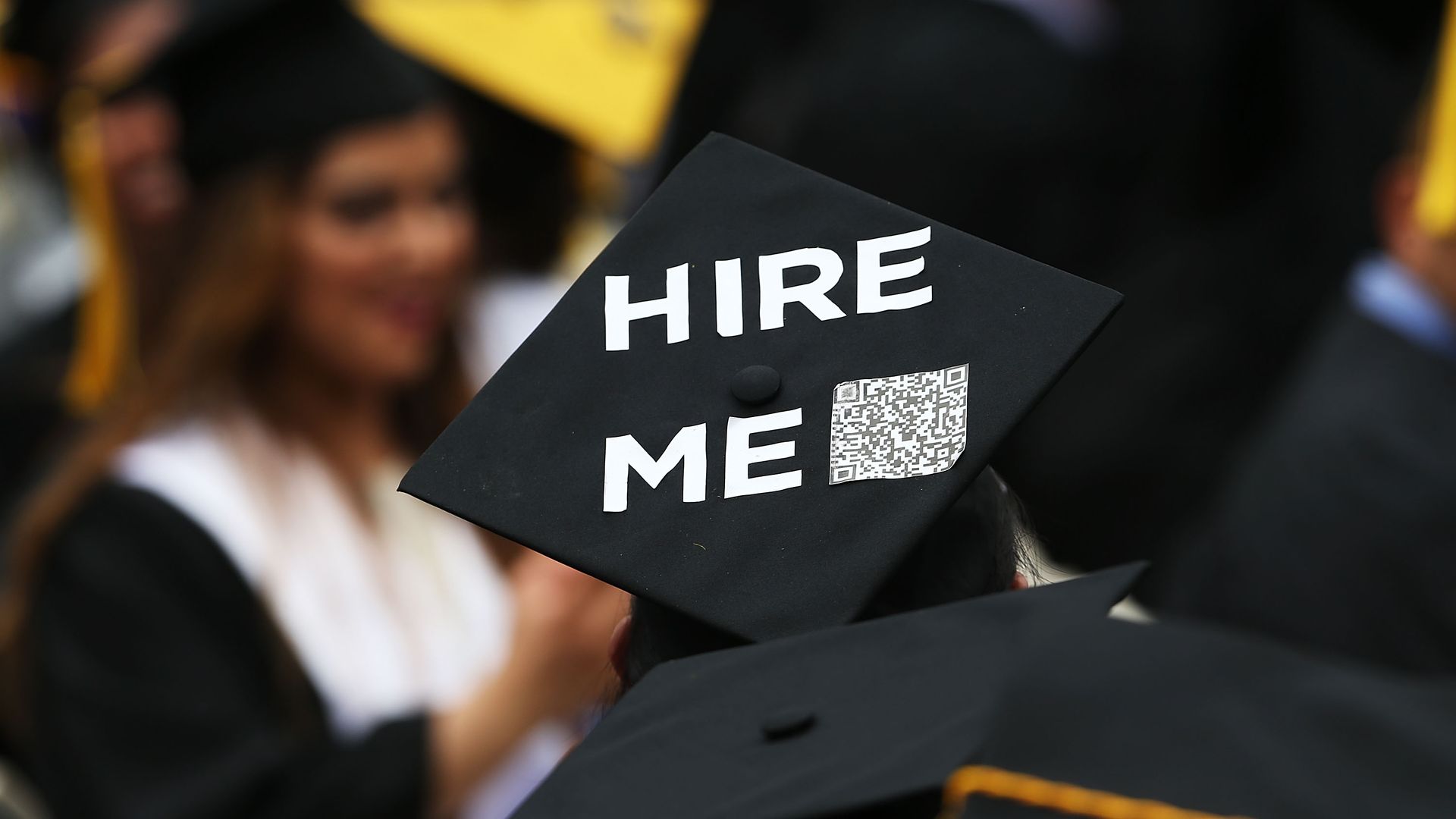 A graduation cap from a 2016 commencement ceremony, reading "Hire Me" with a QR code