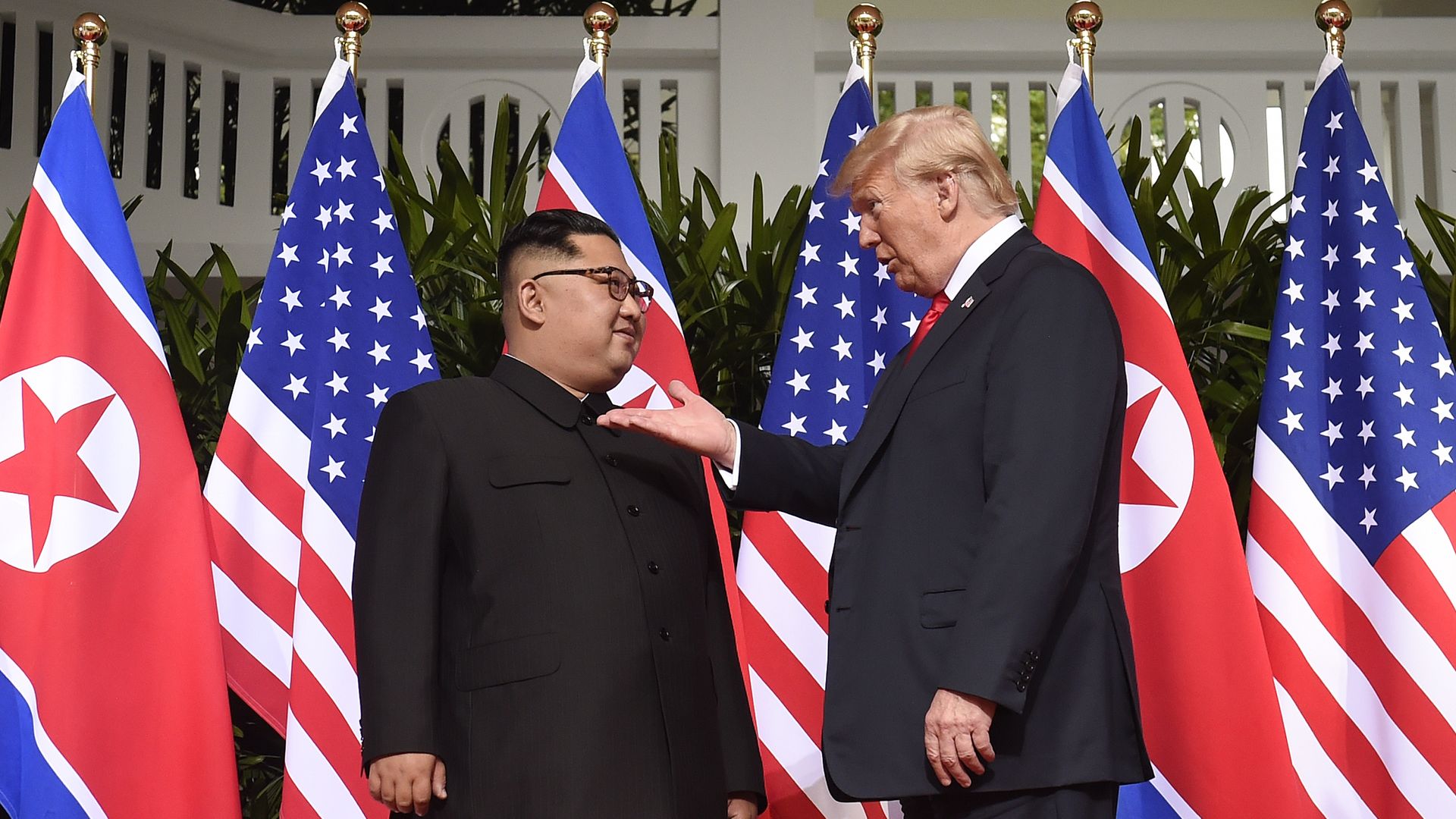 Kim Jong-un and Donald Trump in front of flags