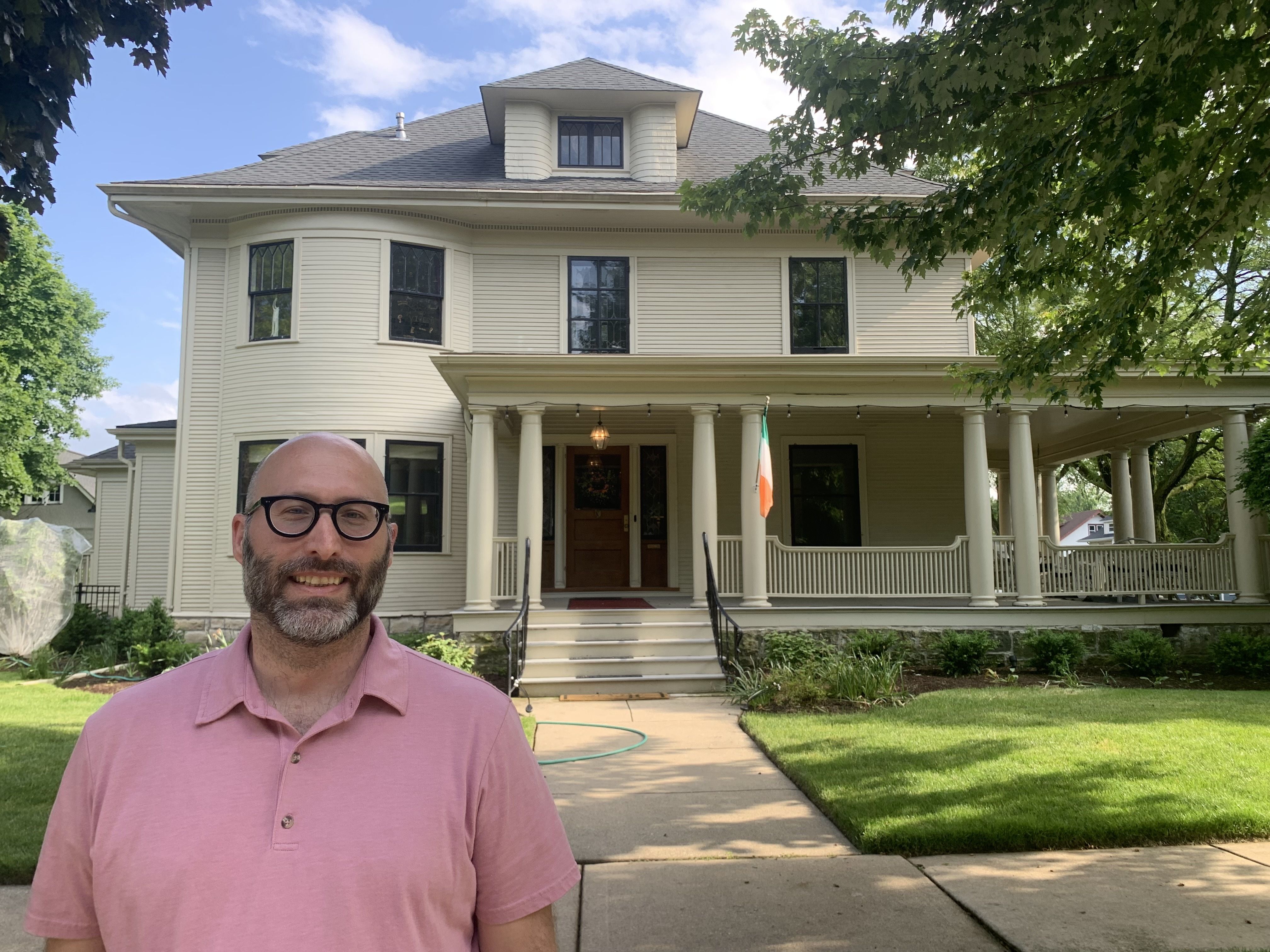 Photo of a man standing in front of a house