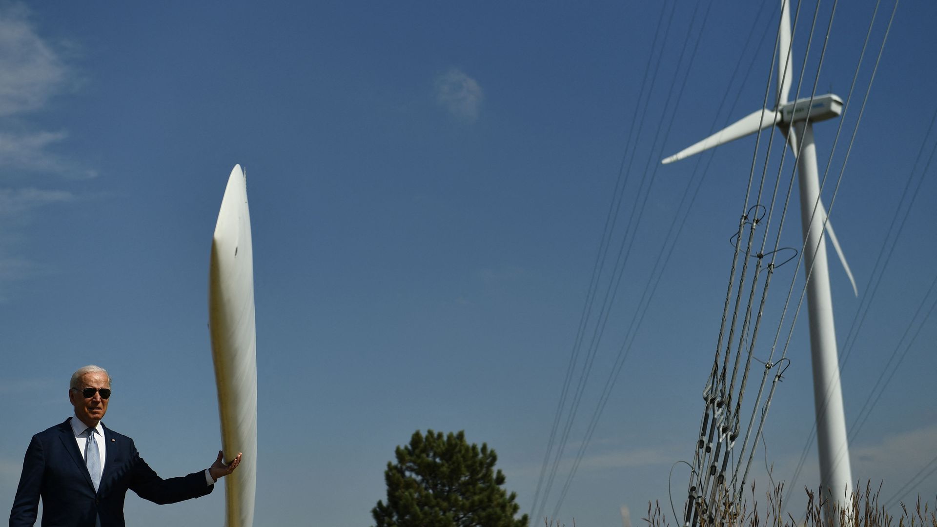President Biden is seen feeling a wind turbine blade while visiting a clean energy site in Colorado.