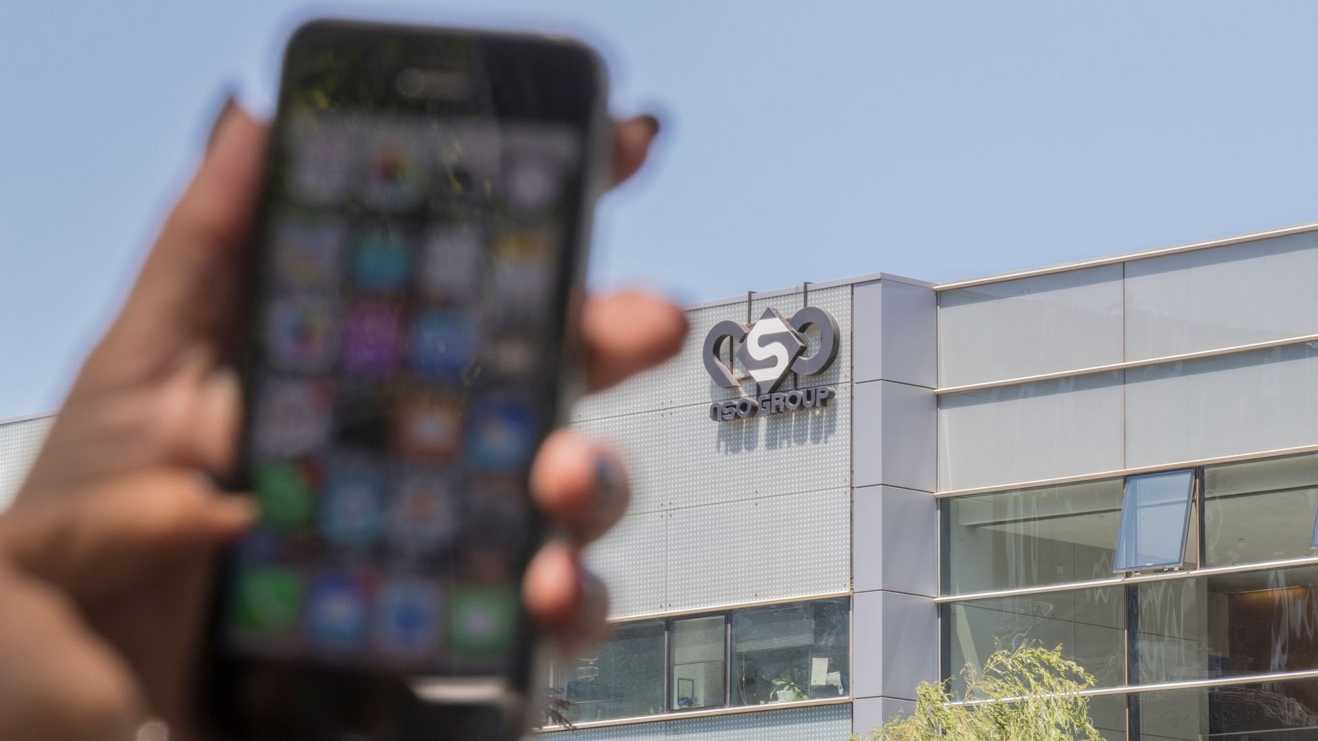 An Israeli woman uses her iPhone in front of the building housing the Israeli NSO group, on August 28, 2016