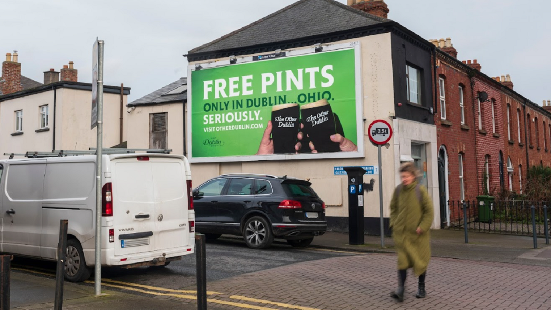 A billboard in Dublin, Ireland reads "Free Pints, Only in Dublin ... Ohio. Seriously." as a woman walks passed. 