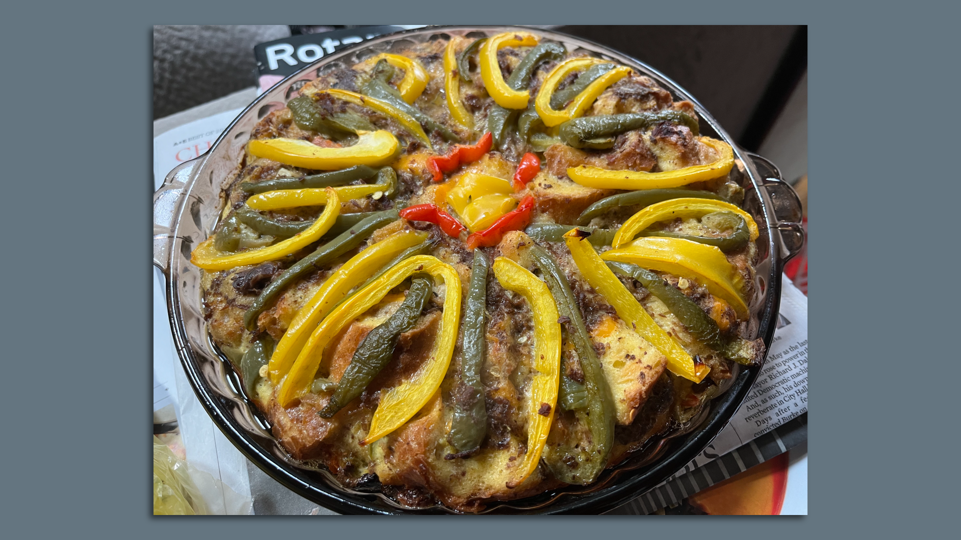 Casserole with yellow and green peppers on top of beef and eggs.