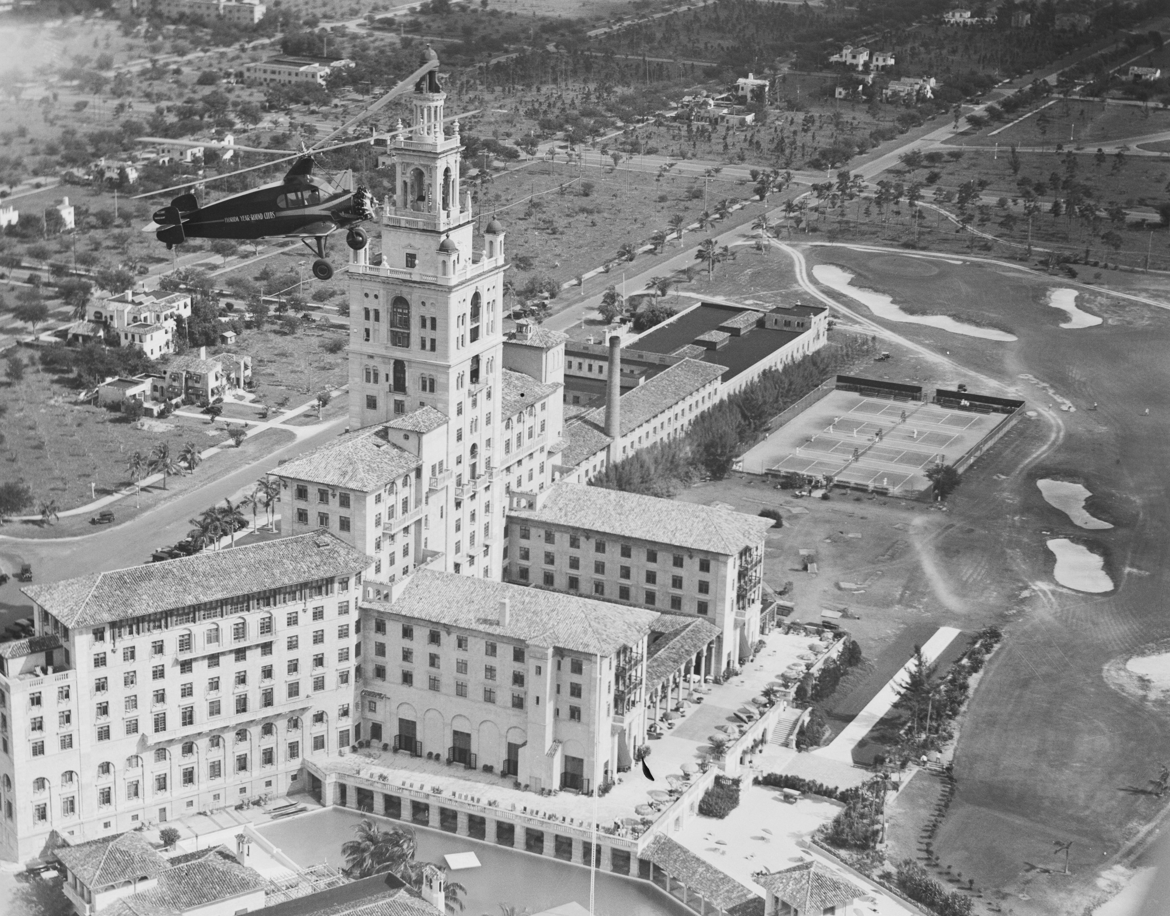 (Original Caption) Aerial Taxi Service. Hovering high above the Miami Biltmore Hotel in Miami, Florida, the world's largest autogiro, also the first such ship of cabin design, makes its first flight after being inaugurated into aerial taxi service for the Florida Year Round Clubs, at Coral Gables, F