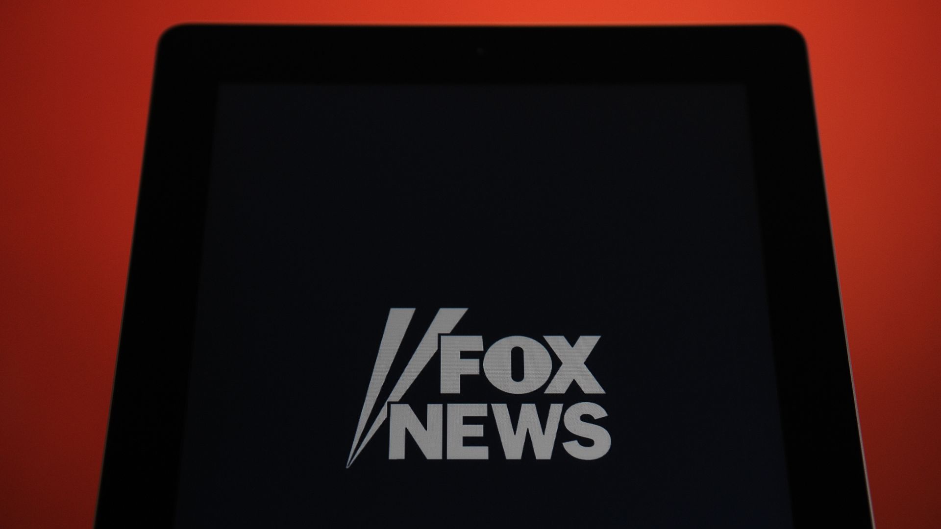 In this image, a large black screen displays the Fox News logo.