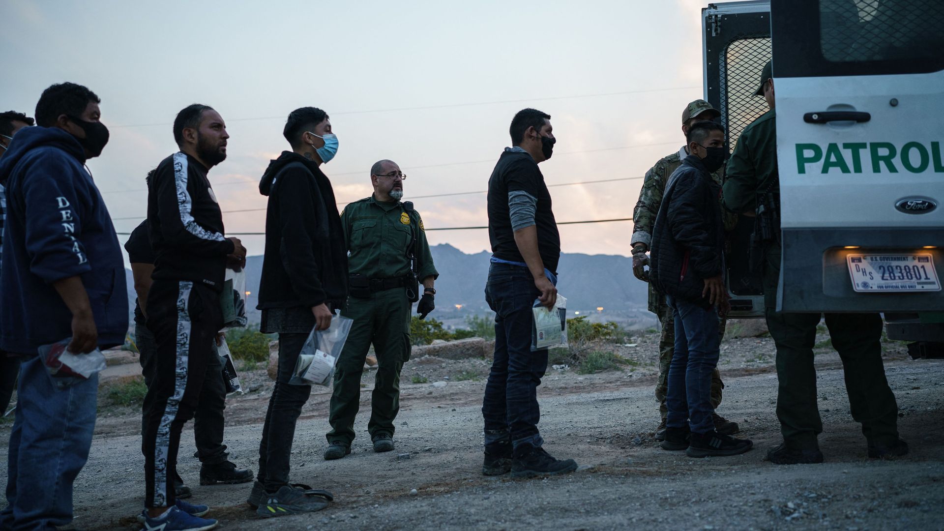 Migrants caught crossing the US-Mexico border are loaded into a transport van by US Border Patrol agents