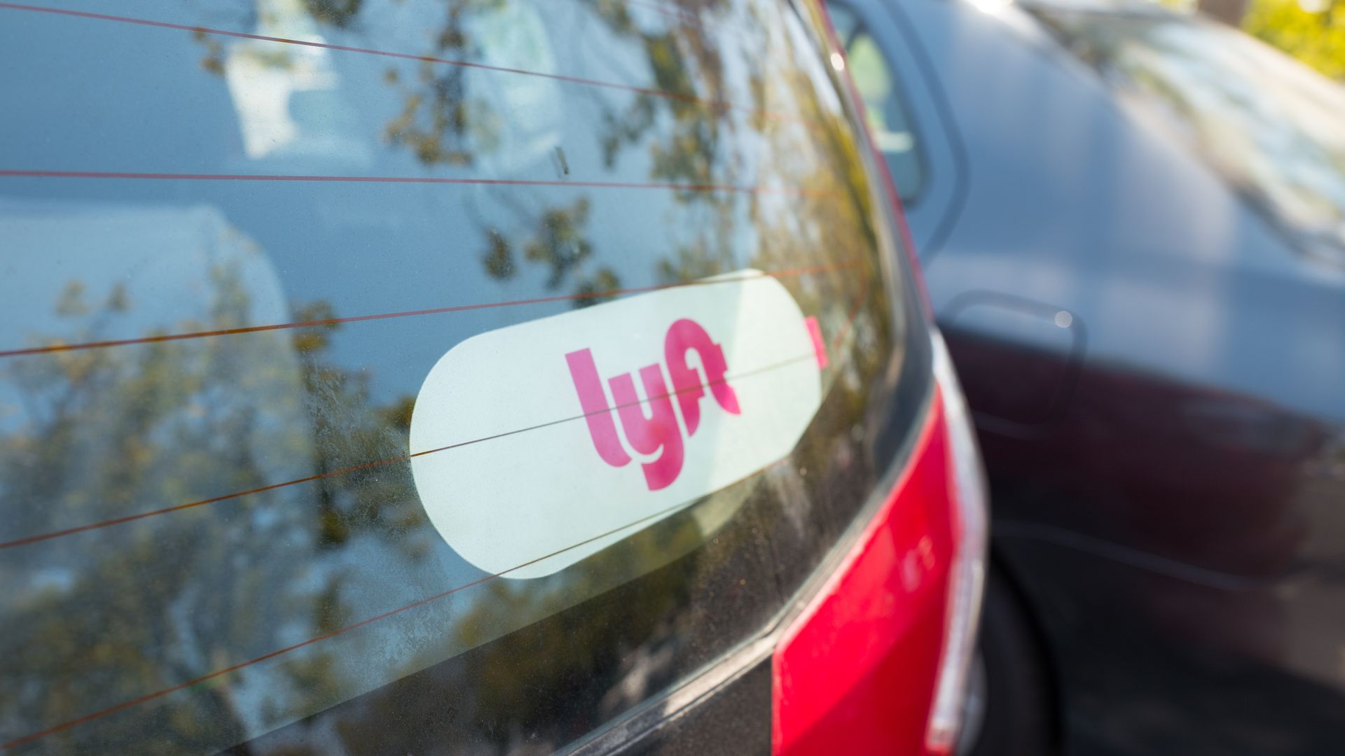 A photo of a sticker reading "Lyft" on the back window of a car.