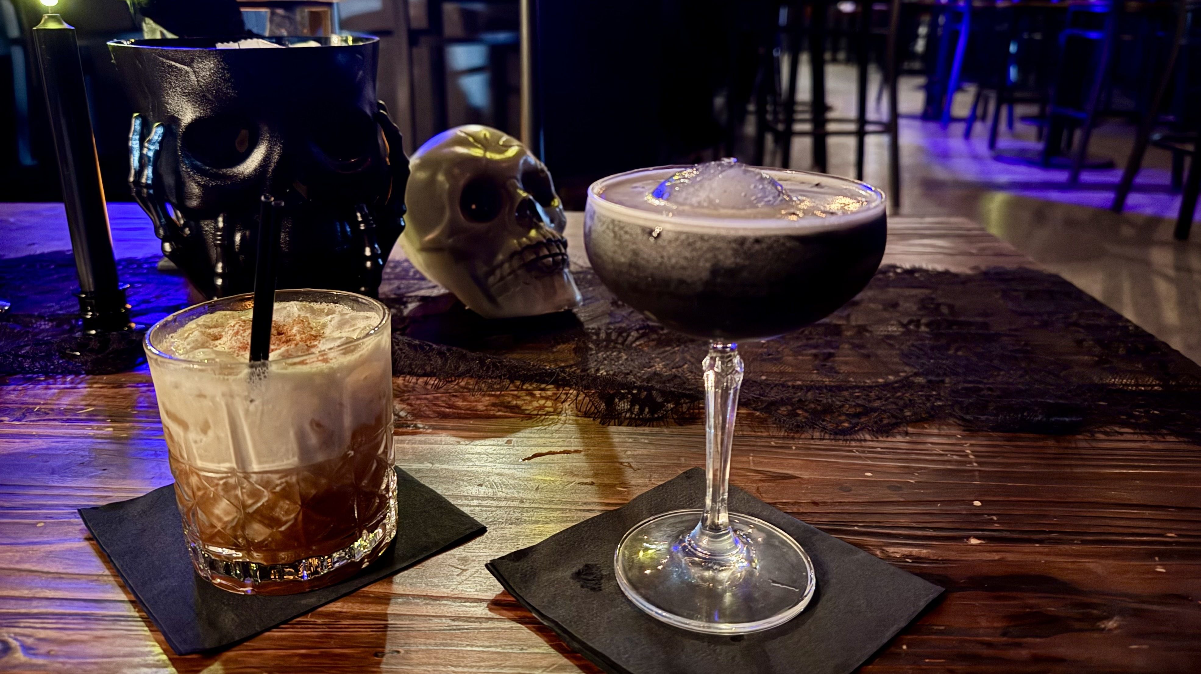 Two drinks with skulls behind them.