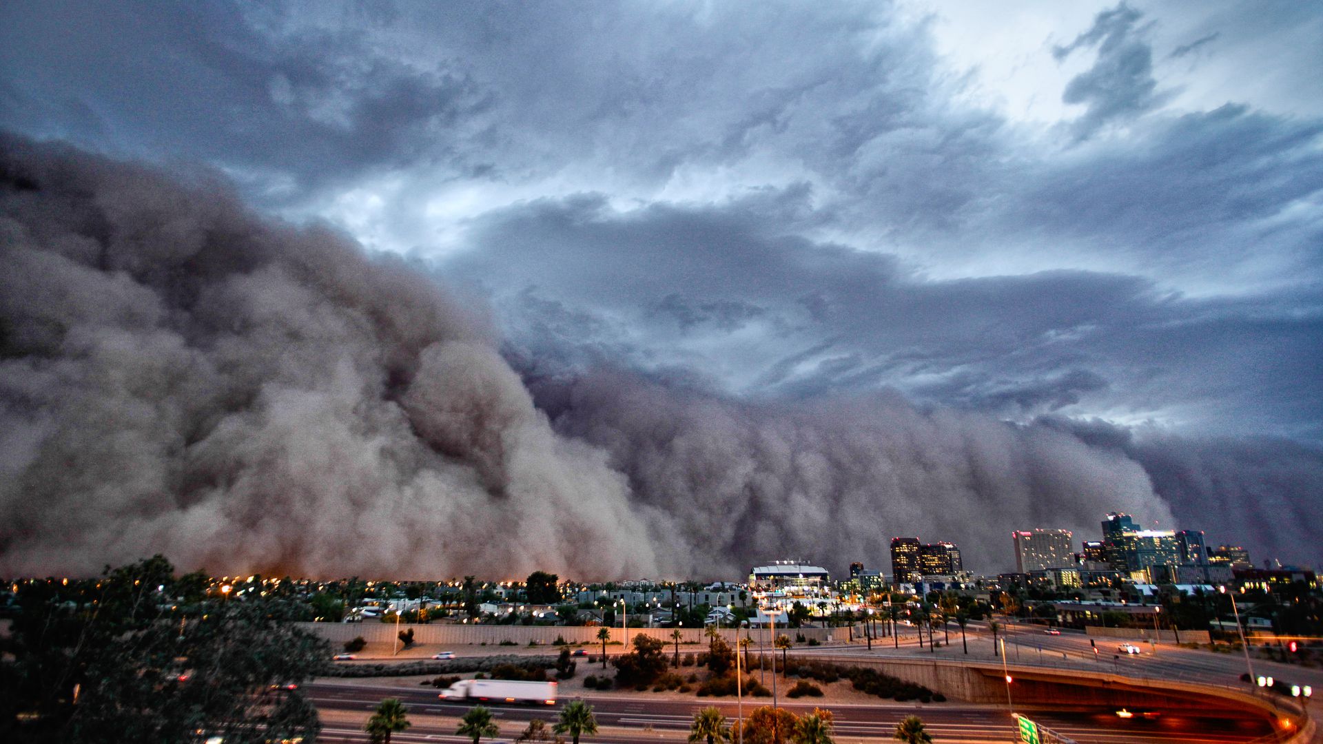 A huge wall of dust envelops a city during a storm. 