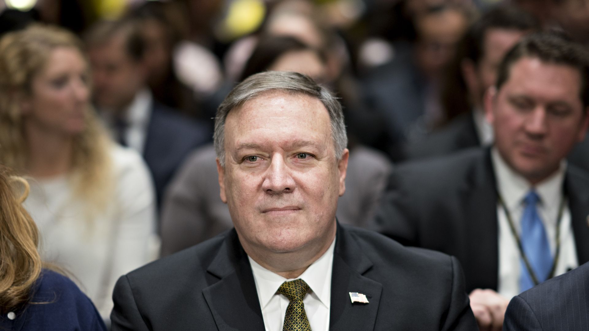 Mike Pompeo sits before a crowd in a room on Capitol Hill.